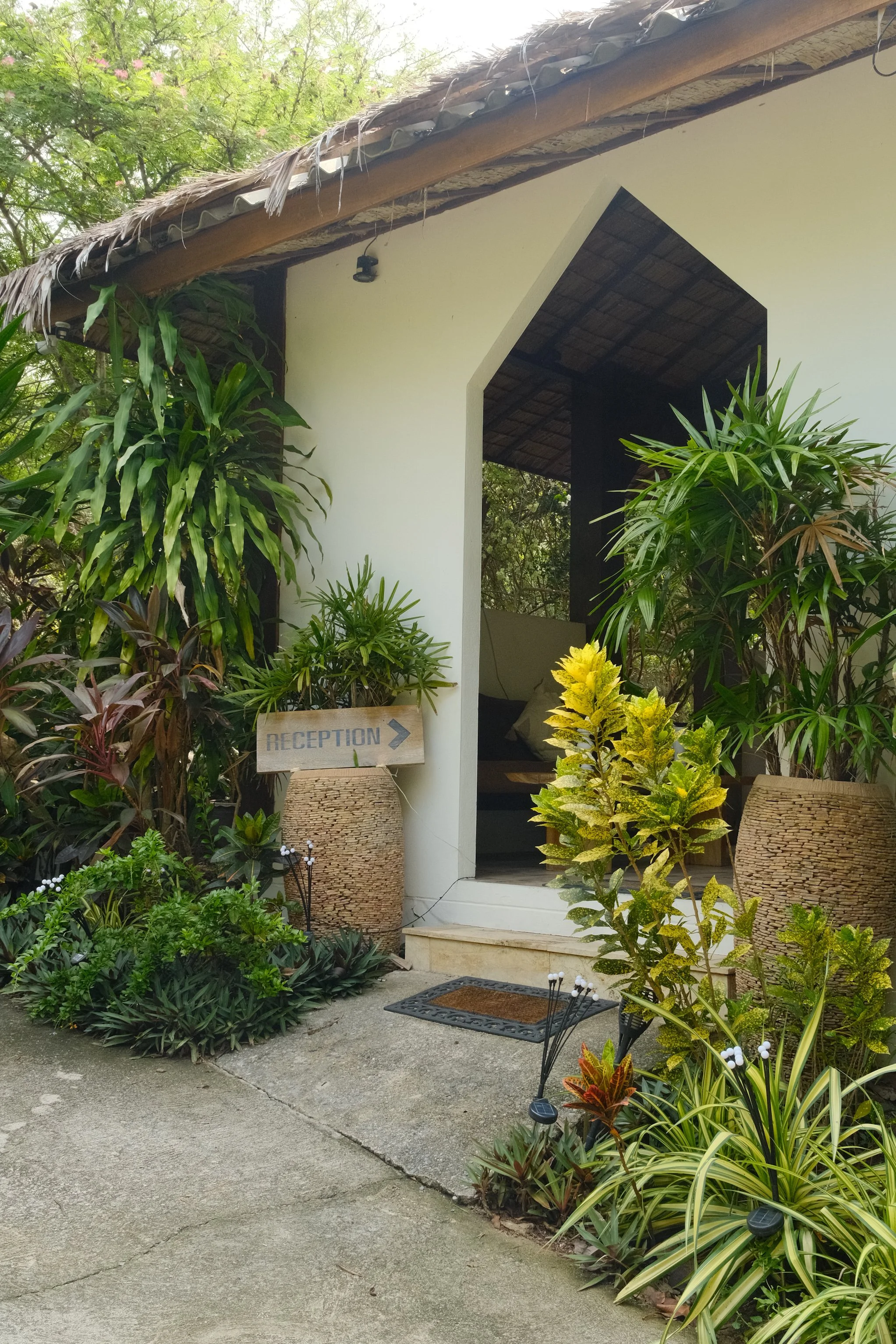 Reception entrance surrounded by colorful tropical plants and lush landscaped gardens