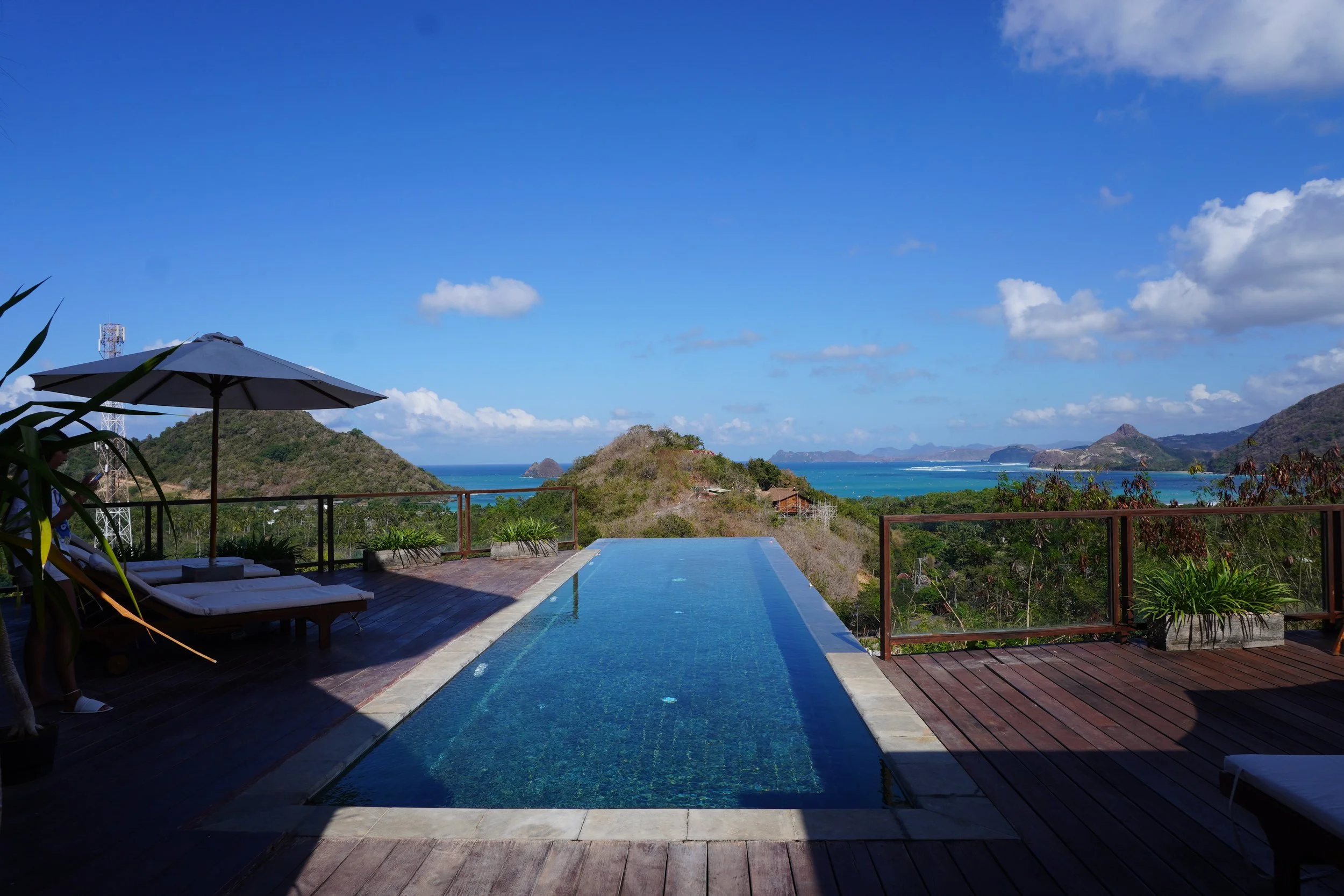 Spacious lounge overlooking Lombok's lush hills through panoramic windows