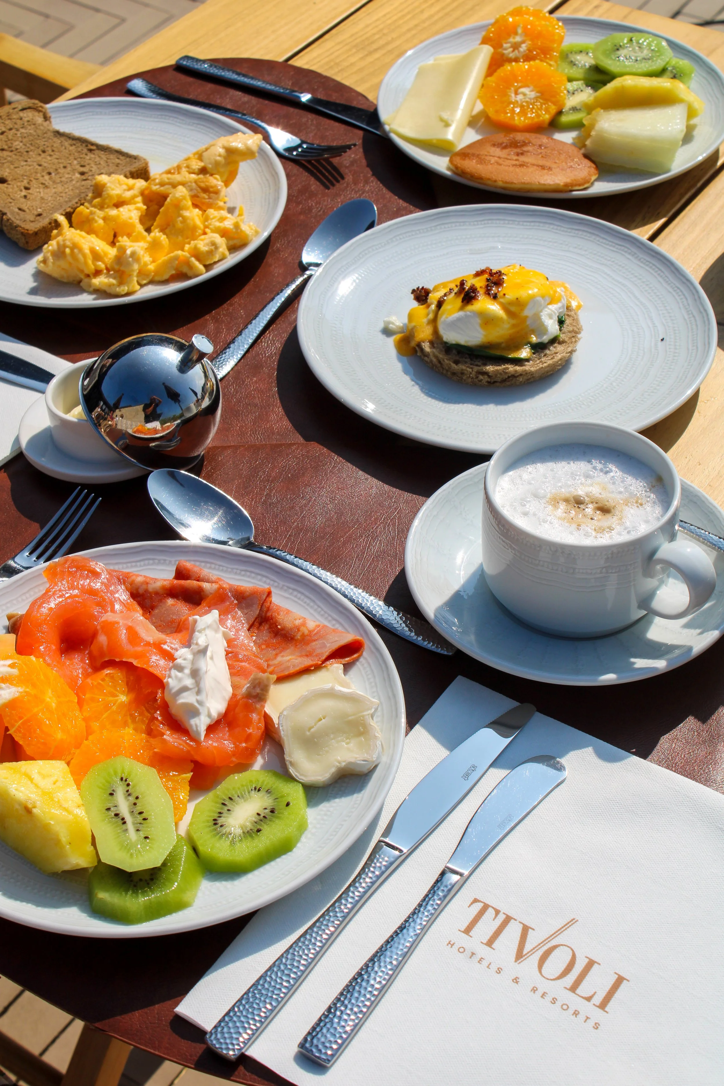 Fresh breakfast selection with seasonal fruit, eggs, pastries, and specialty coffee