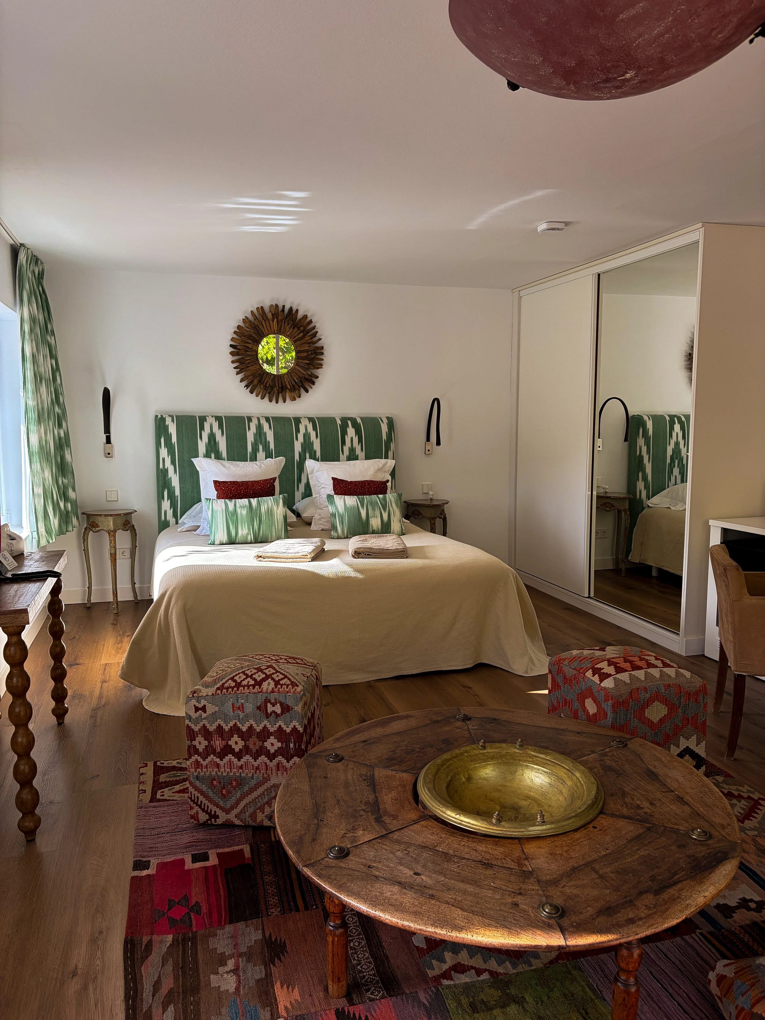 Bright guest room with handcrafted furnishings, natural light, and traditional accents