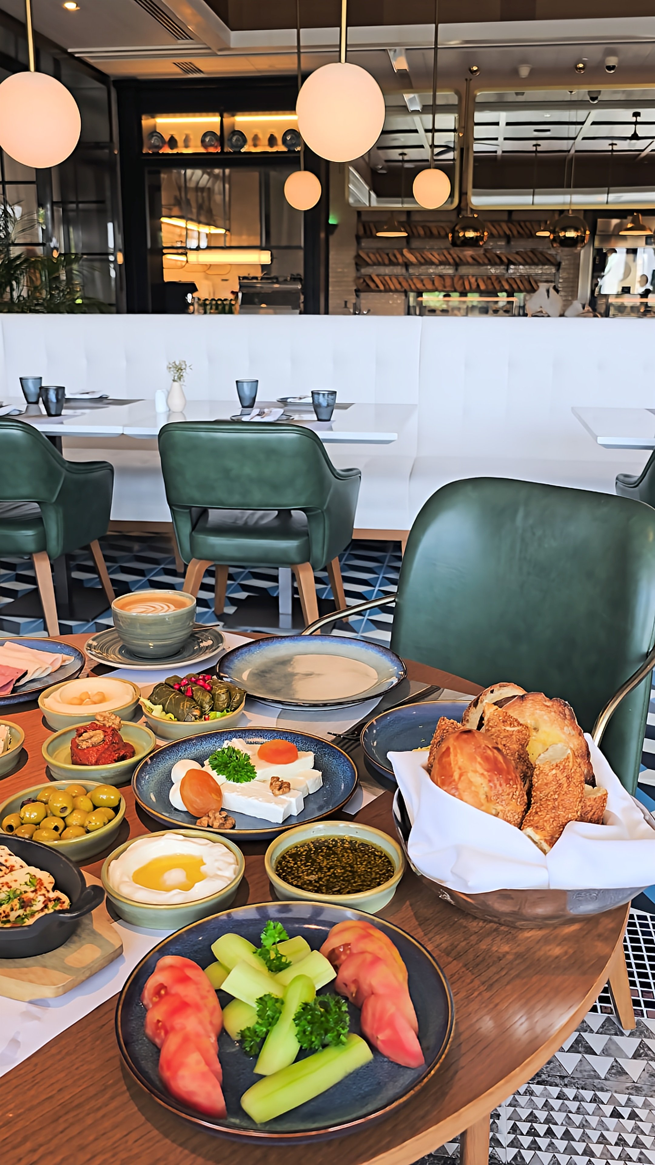 Luxury hotel breakfast spread featuring fresh bread, cheeses, olives, vegetables, traditional dips, and freshly prepared coffee
