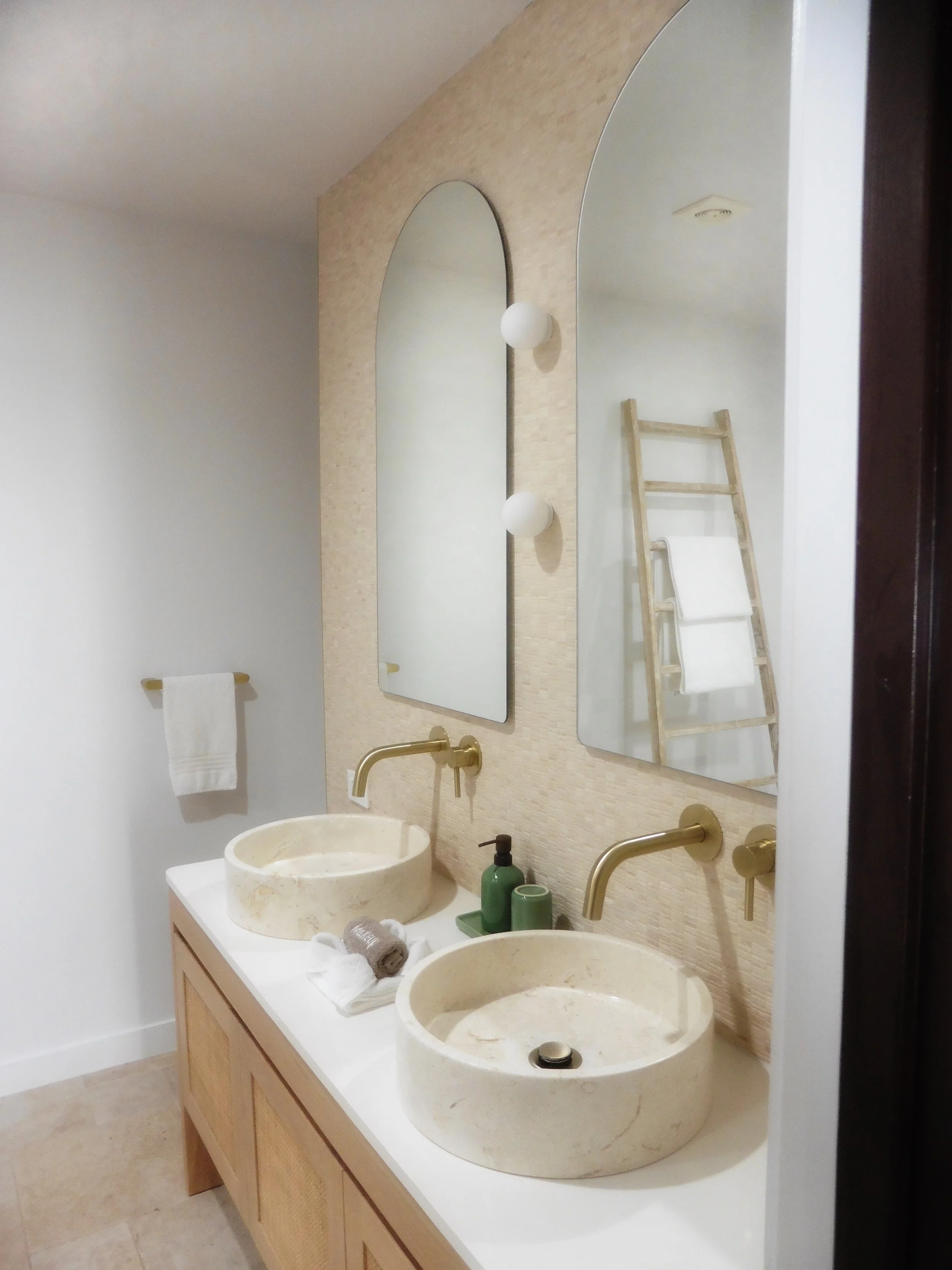 Minimal tropical bathroom with double stone sinks at Sea Change Villas in Rarotonga, Cook Islands