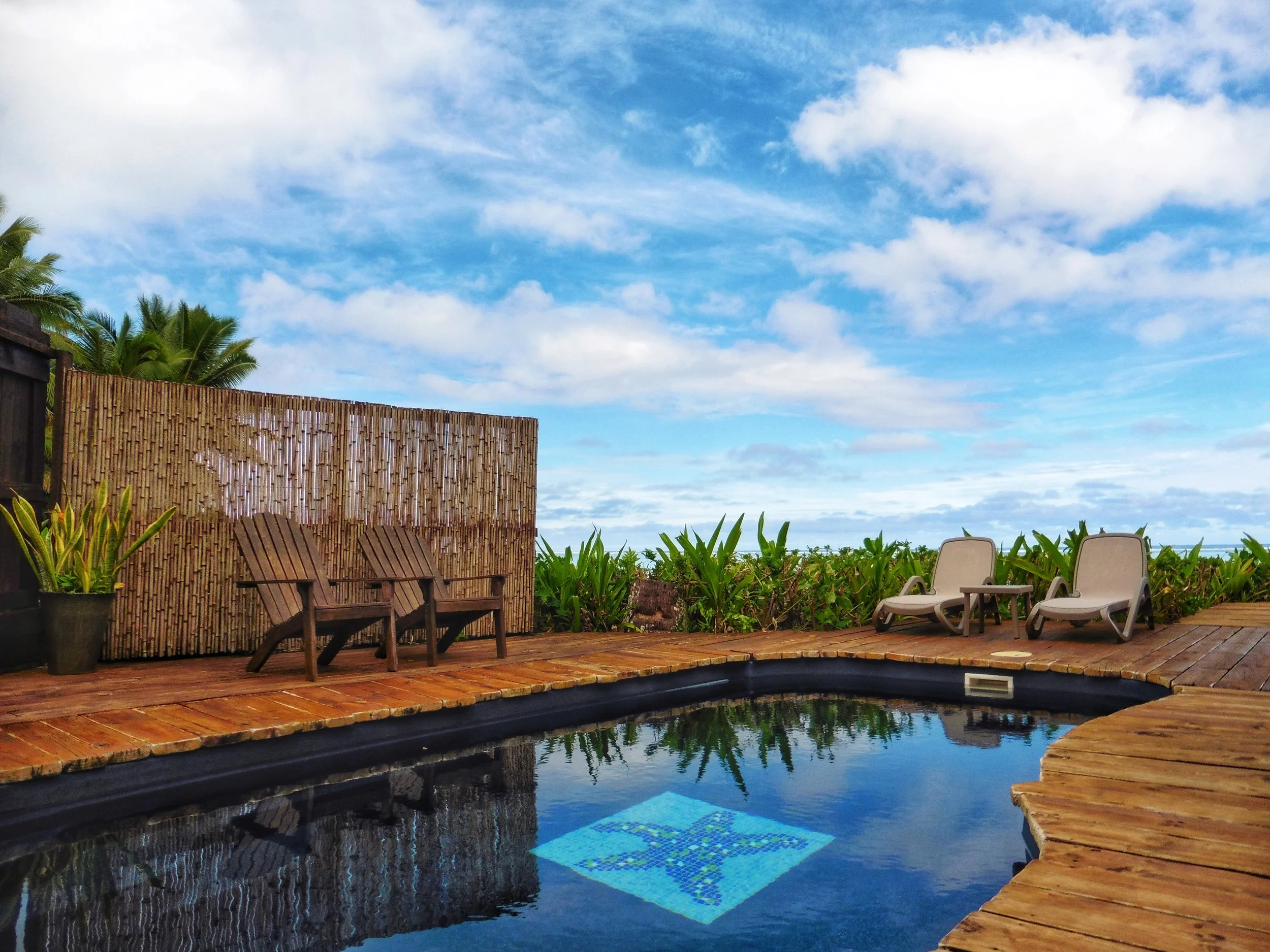 Private oceanfront plunge pool with timber decking and tropical gardens overlooking the beach