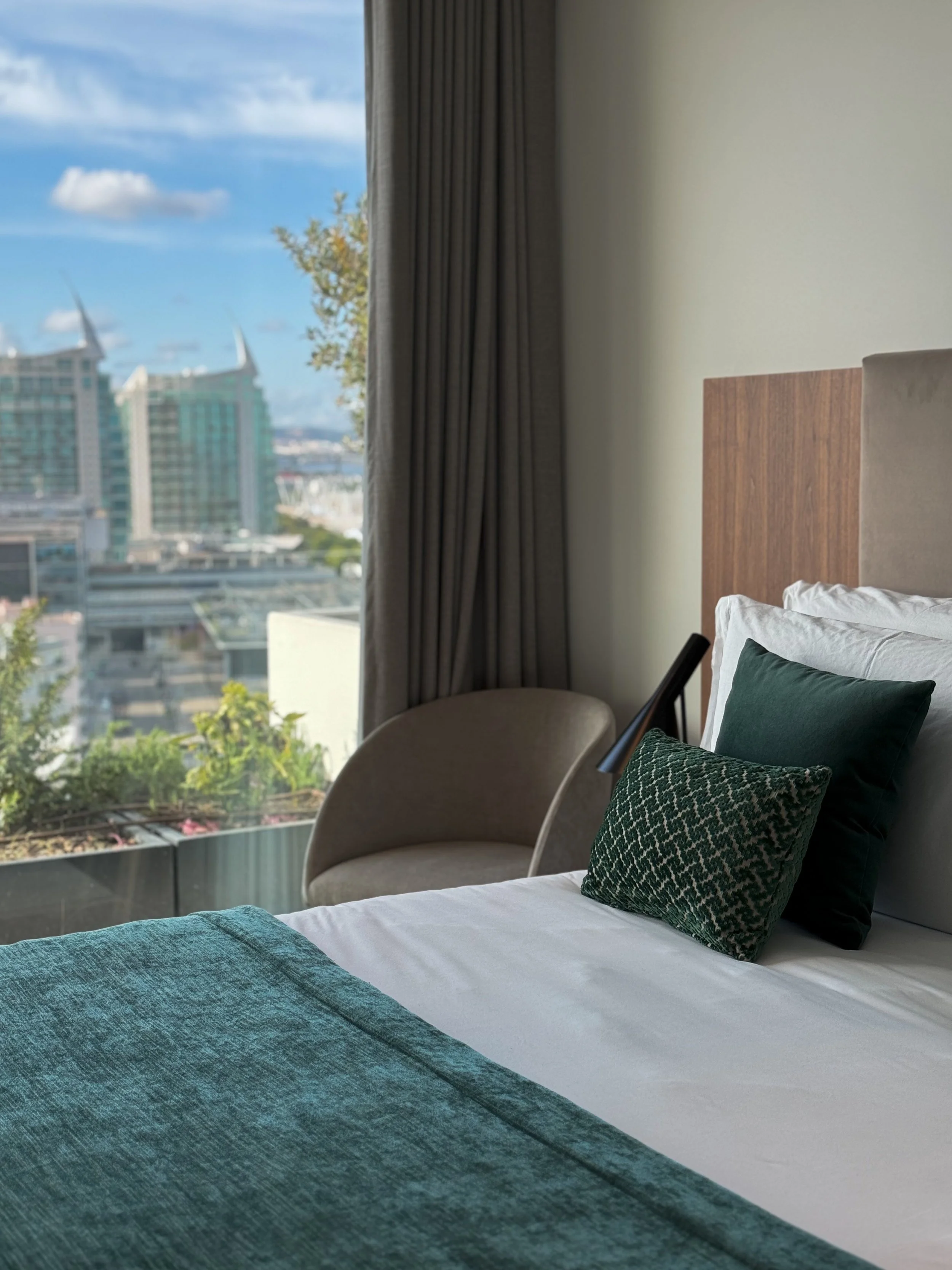 Bright guest room with plush bedding and panoramic views across Lisbon