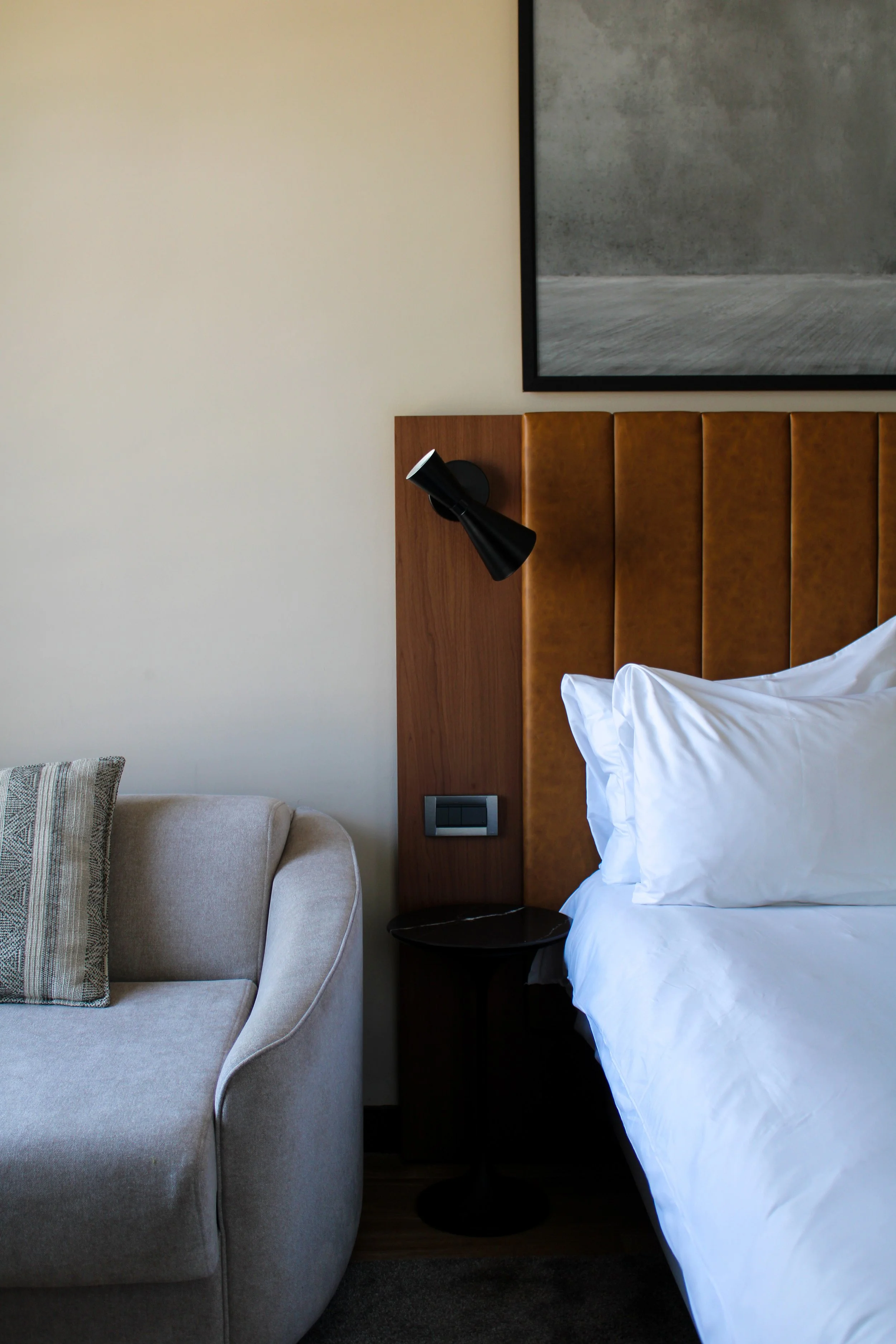 Comfortable guest room with upholstered headboard and modern furnishings