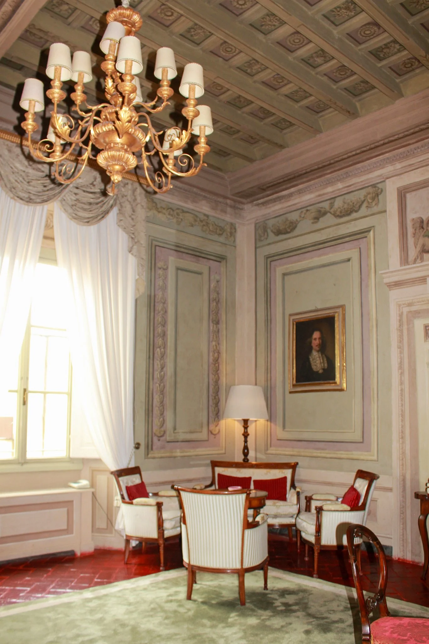 Elegant salon with gilded chandelier, antique armchairs, and pastel wall frescoes, Palazzo Niccolini al Duomo – Florence, Italy.