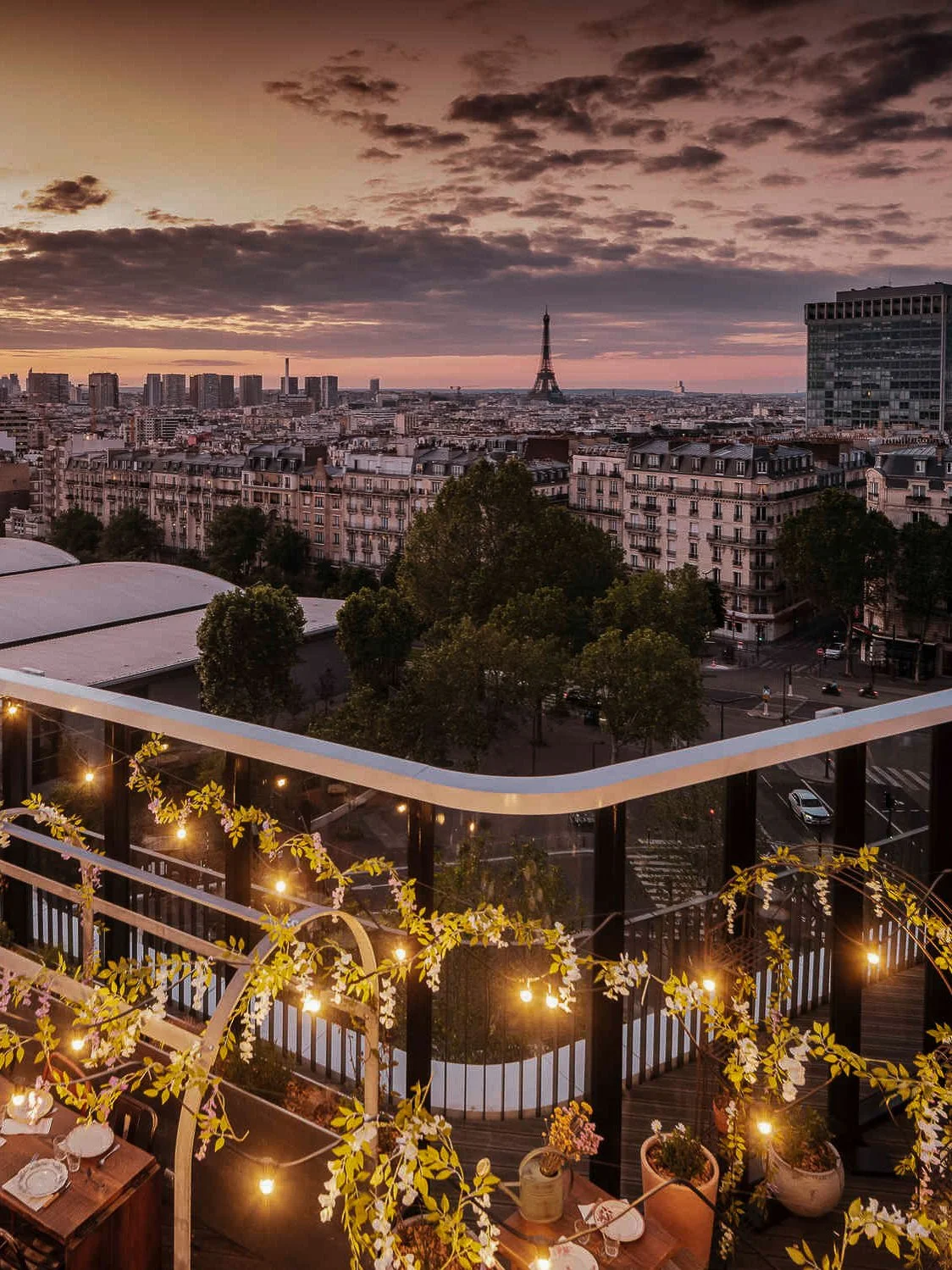 Panoramic rooftop terrace overlooking Paris with the Eiffel Tower at sunset