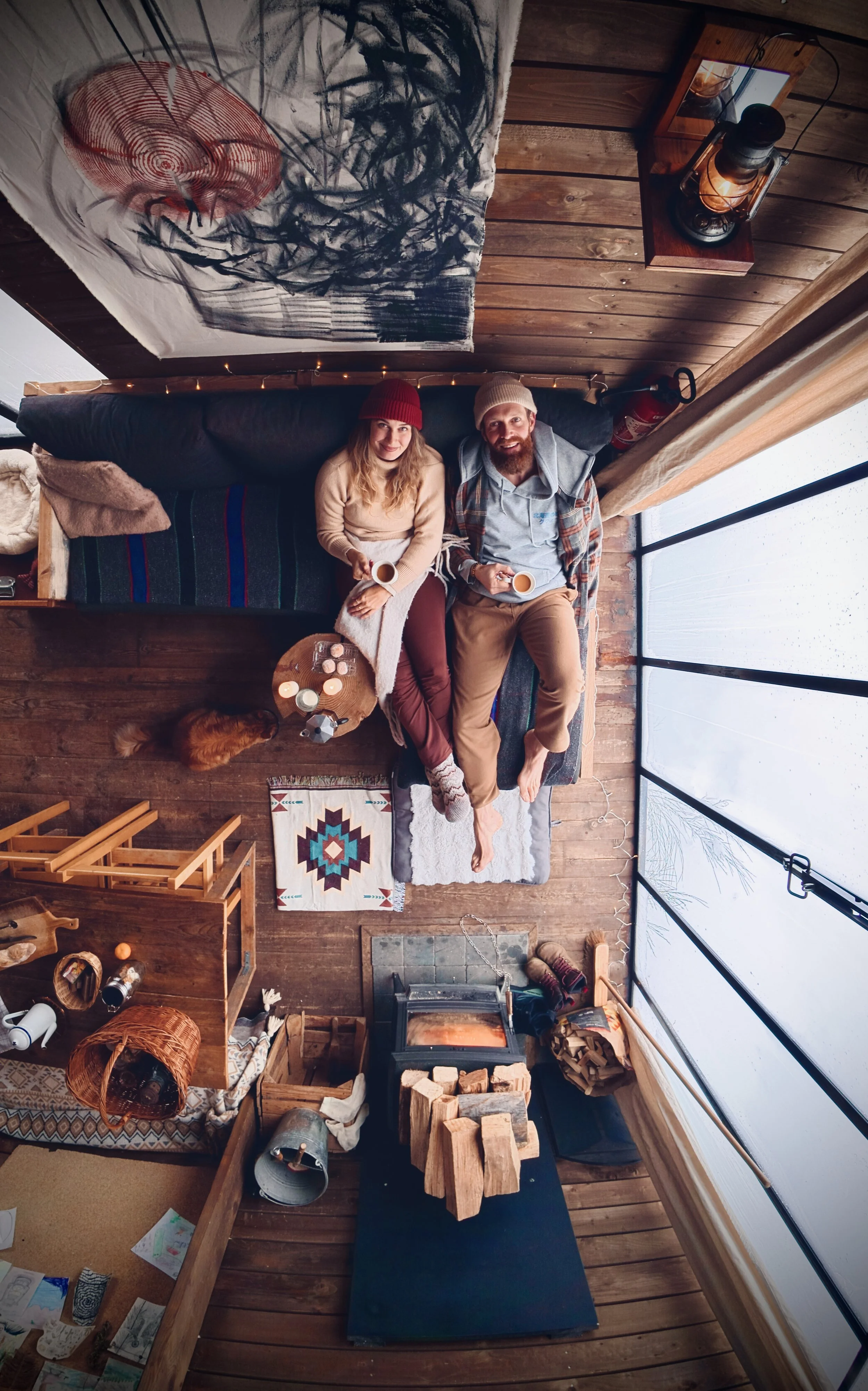 Overhead view of a cosy forest cabin with wood-burning stove and relaxing lounge area