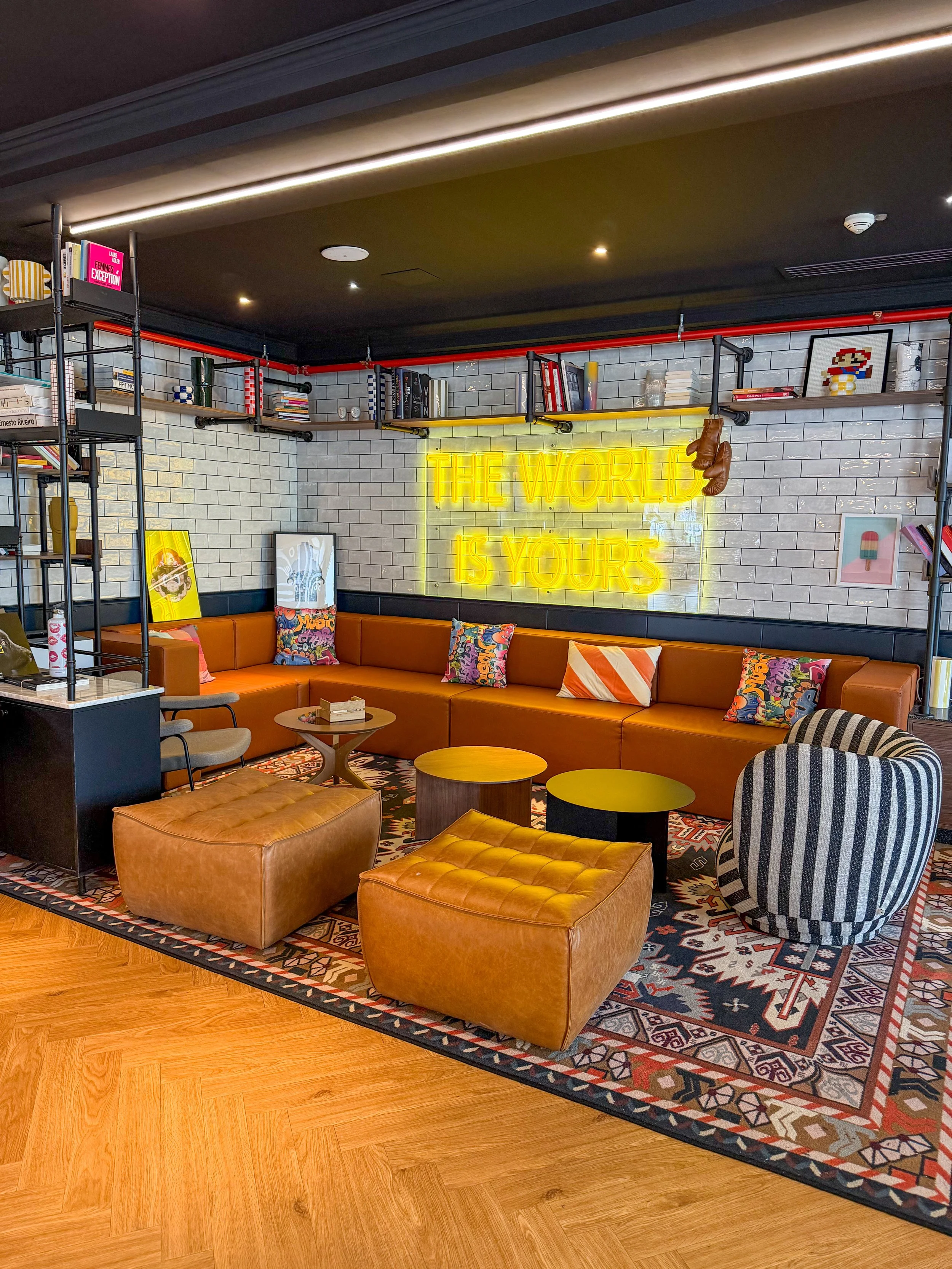 Stylish communal lounge with neon artwork, designer furniture, and vibrant social atmosphere