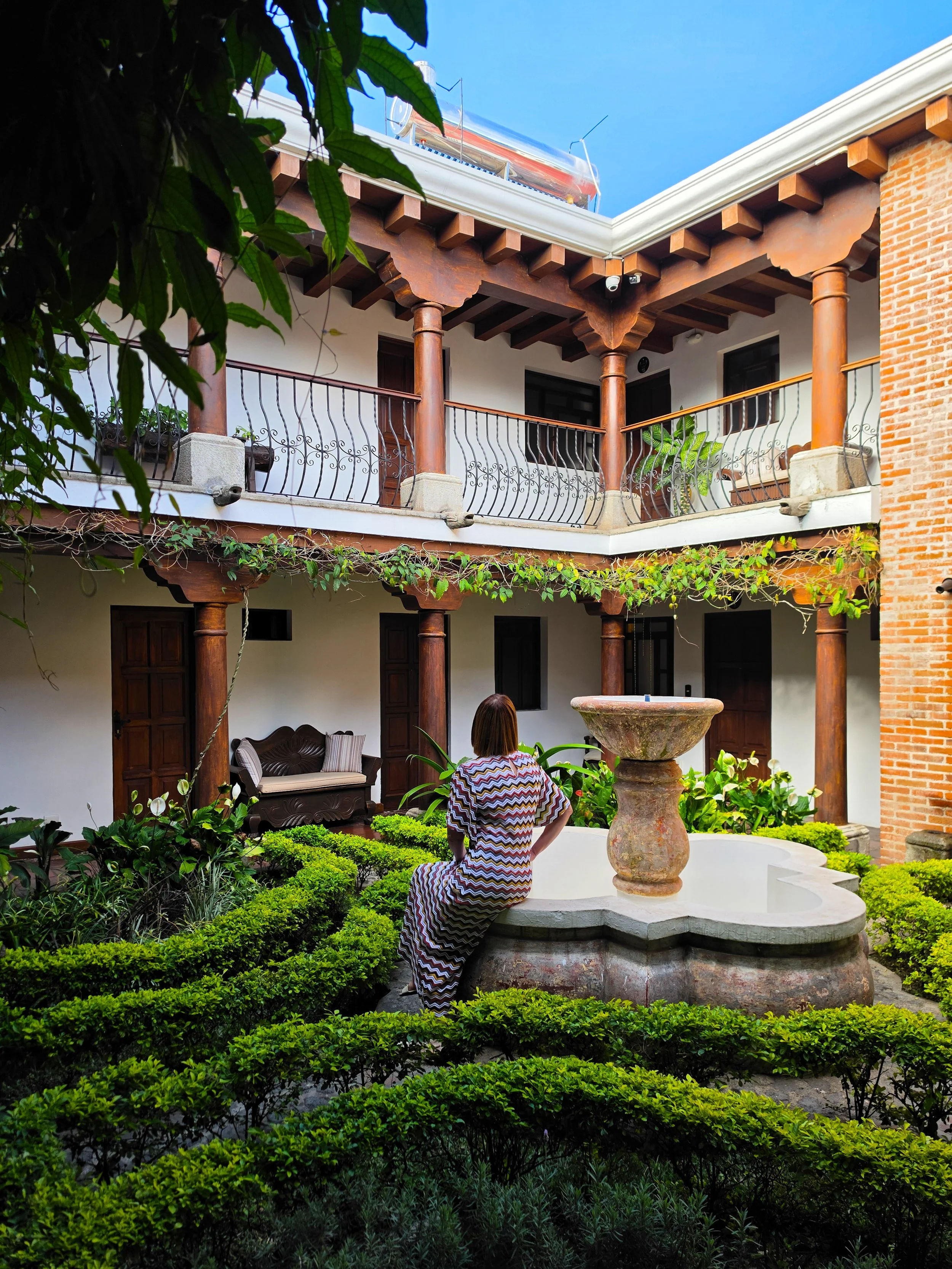 Relaxing beside a tranquil courtyard fountain surrounded by lush gardens