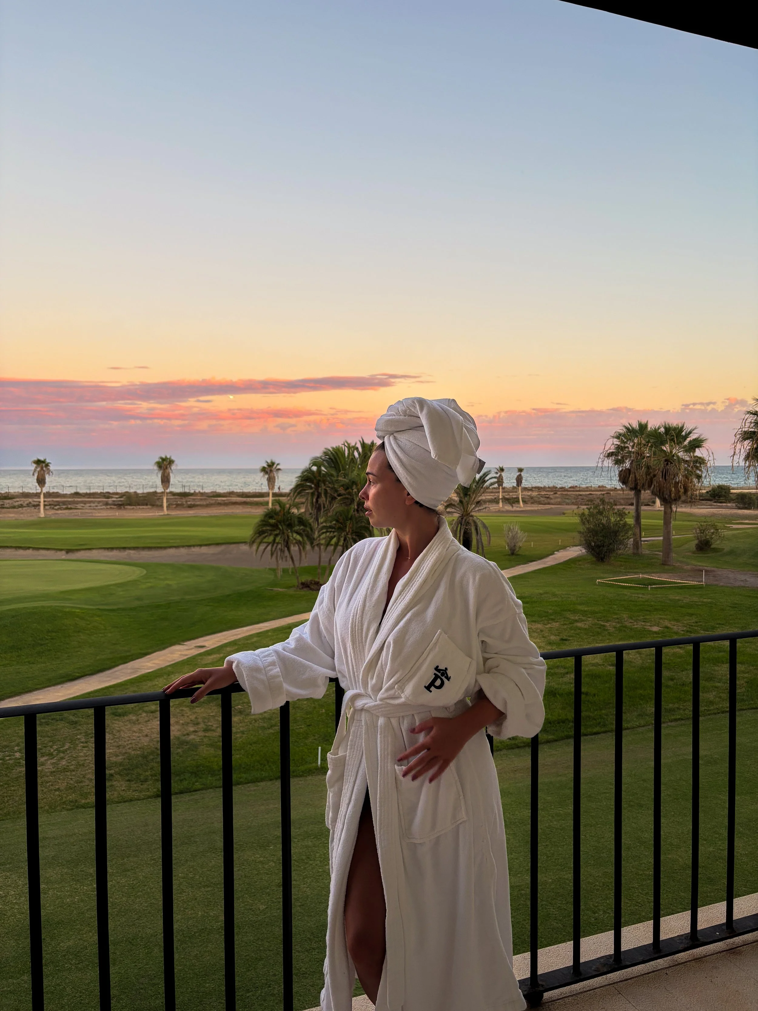 Guest enjoying a peaceful sunset from a balcony overlooking the golf course