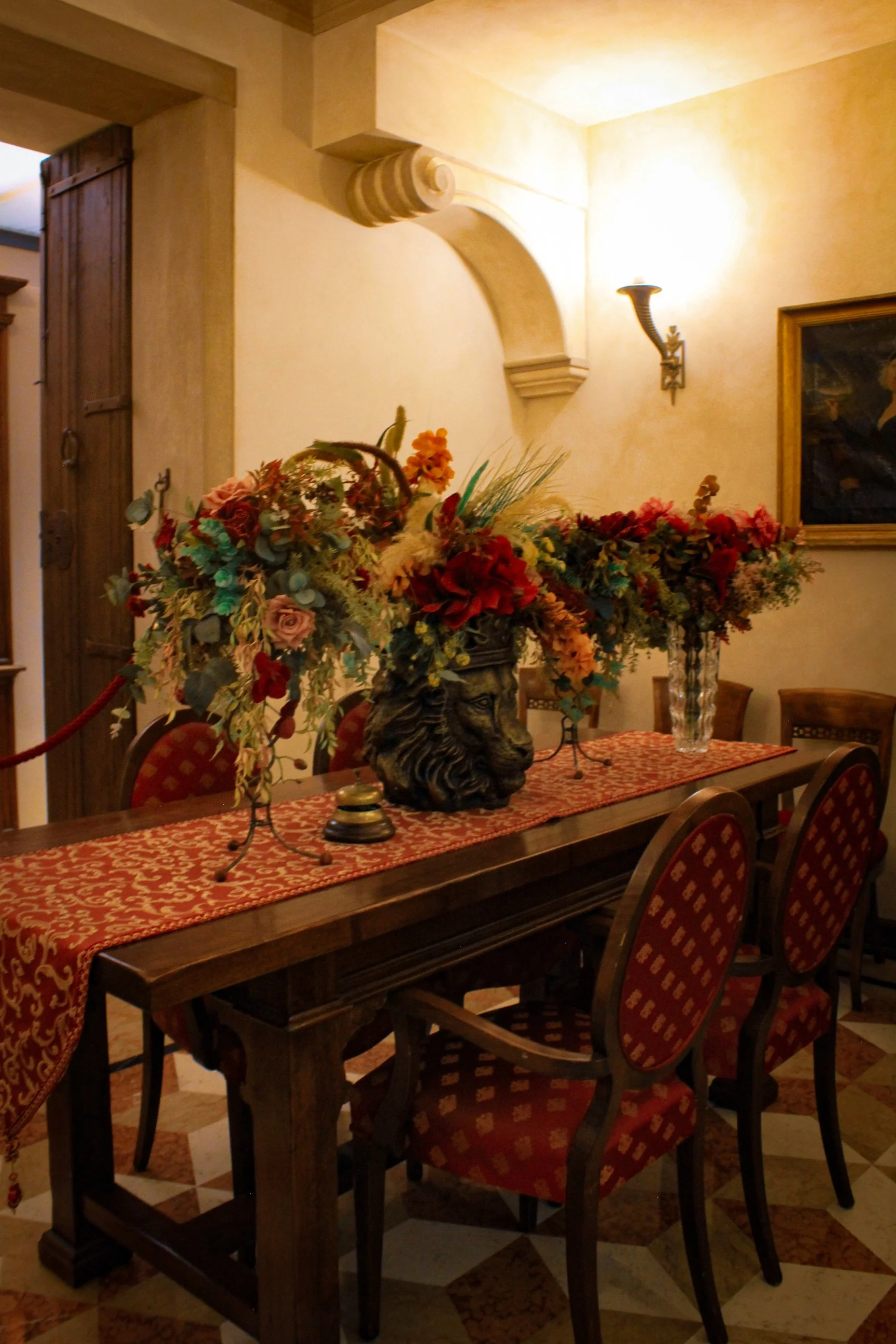 Elegant dining table with floral centerpiece, arched ceilings, and warm ambient lighting, Art Hotel Commercianti – Bologna, Italy.