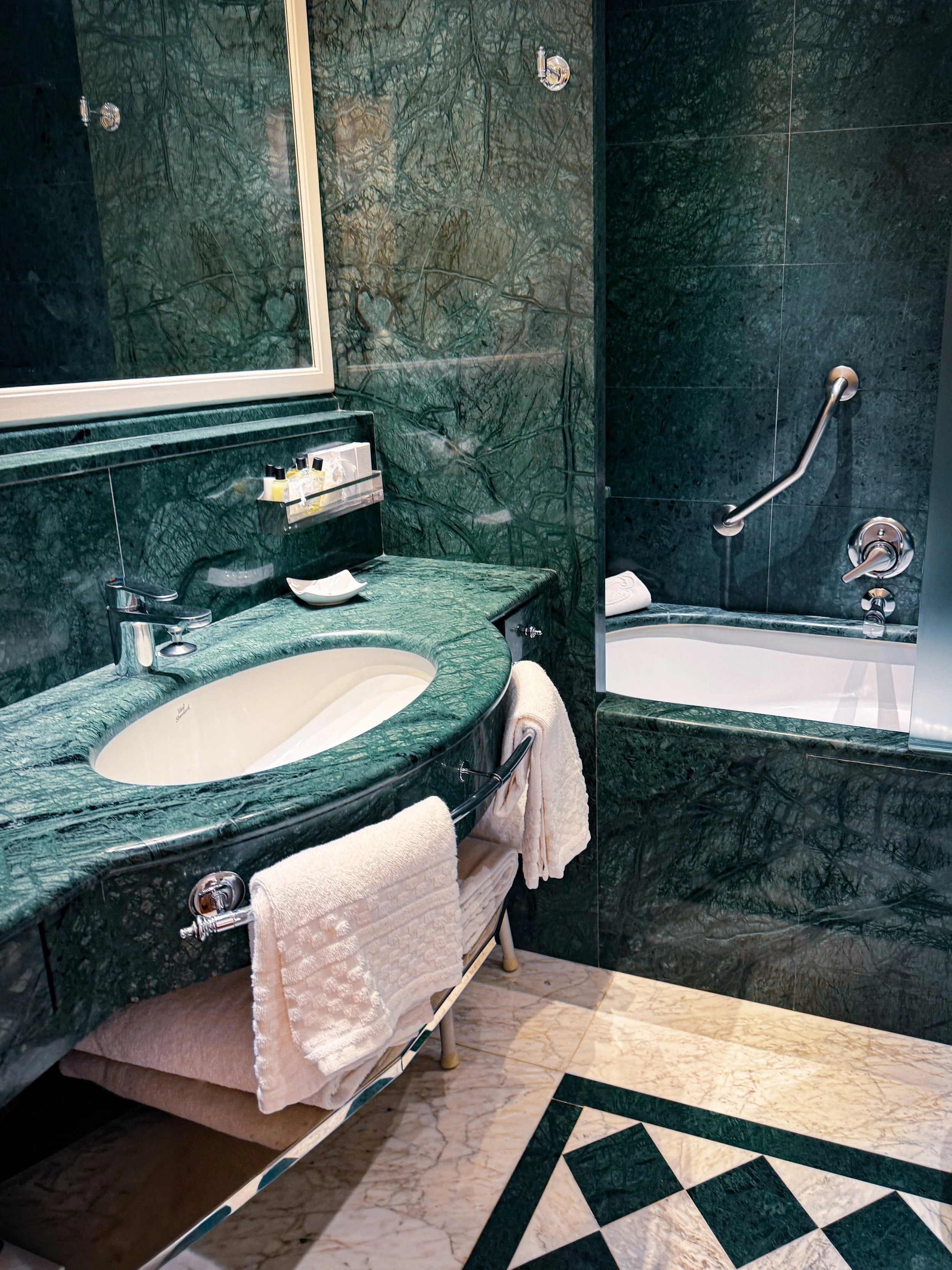 Marble bathroom with green stone vanity and bathtub combination, Art Hotel Commercianti – Bologna, Italy.