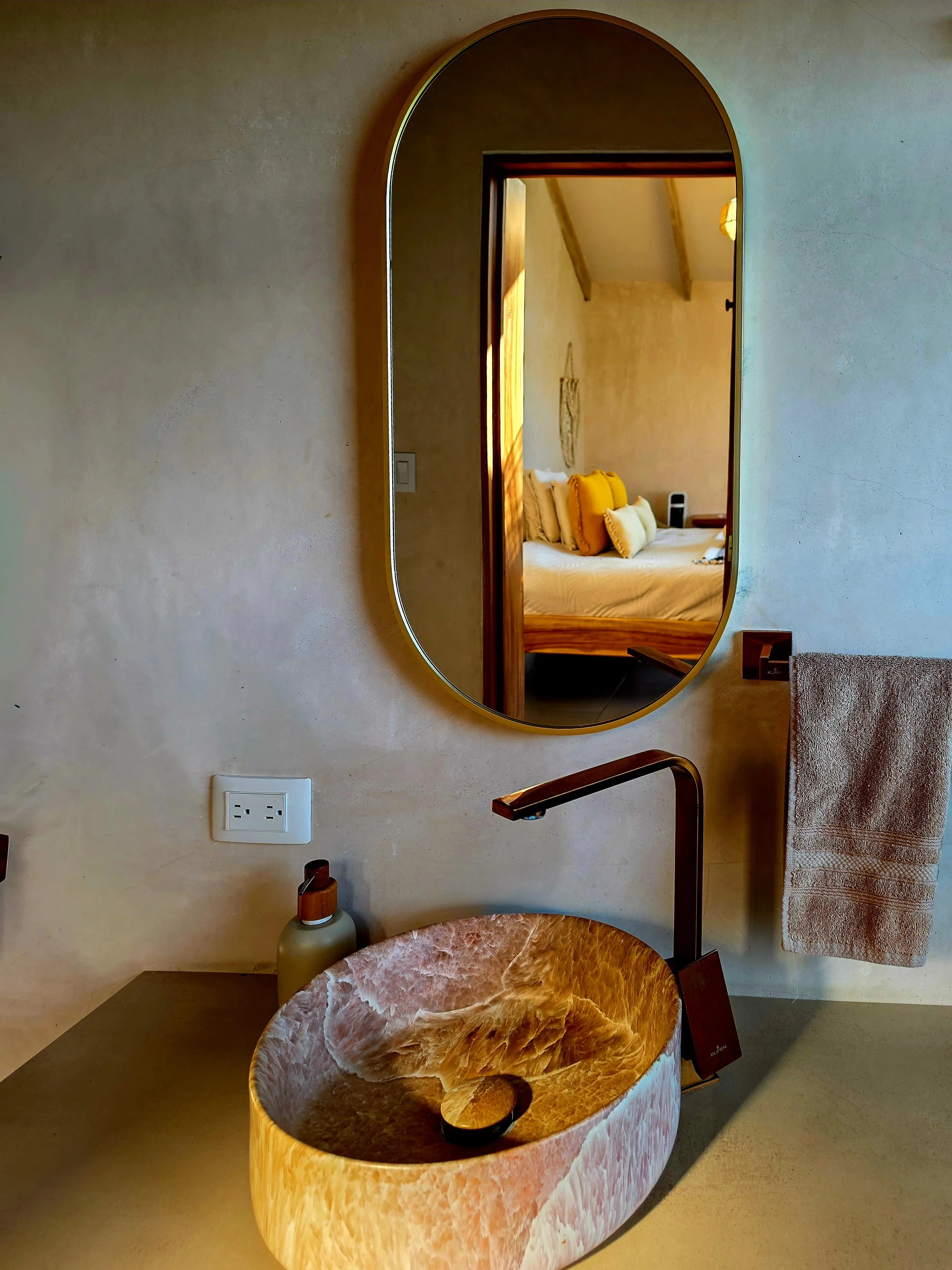 Natural stone vessel sink with handcrafted finishes and minimalist bathroom design