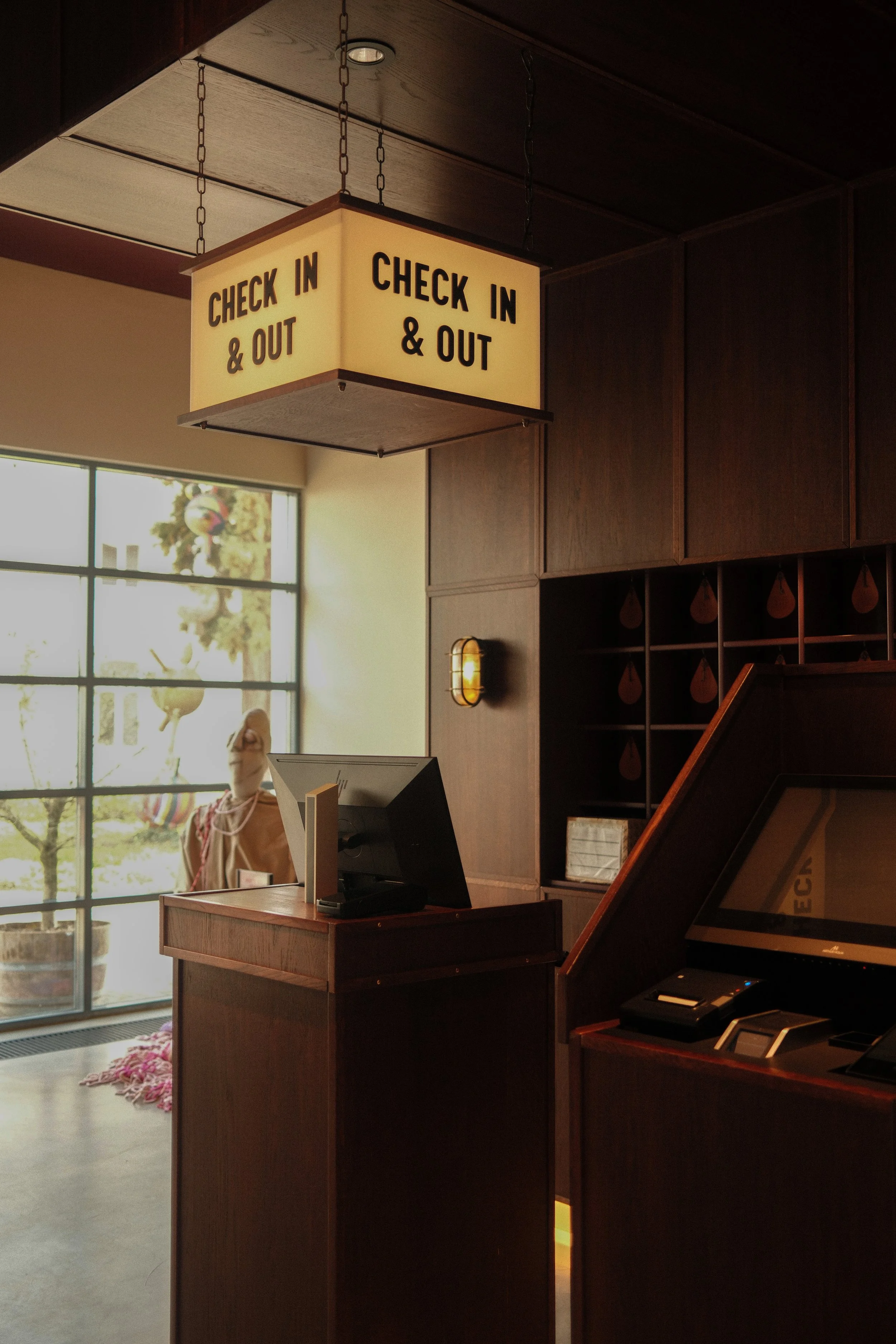 Check-in desk with warm wood interiors and vintage-inspired signage welcoming guests into a boutique stay, Château St. Gerlach – Vaeshartelt Maastricht.