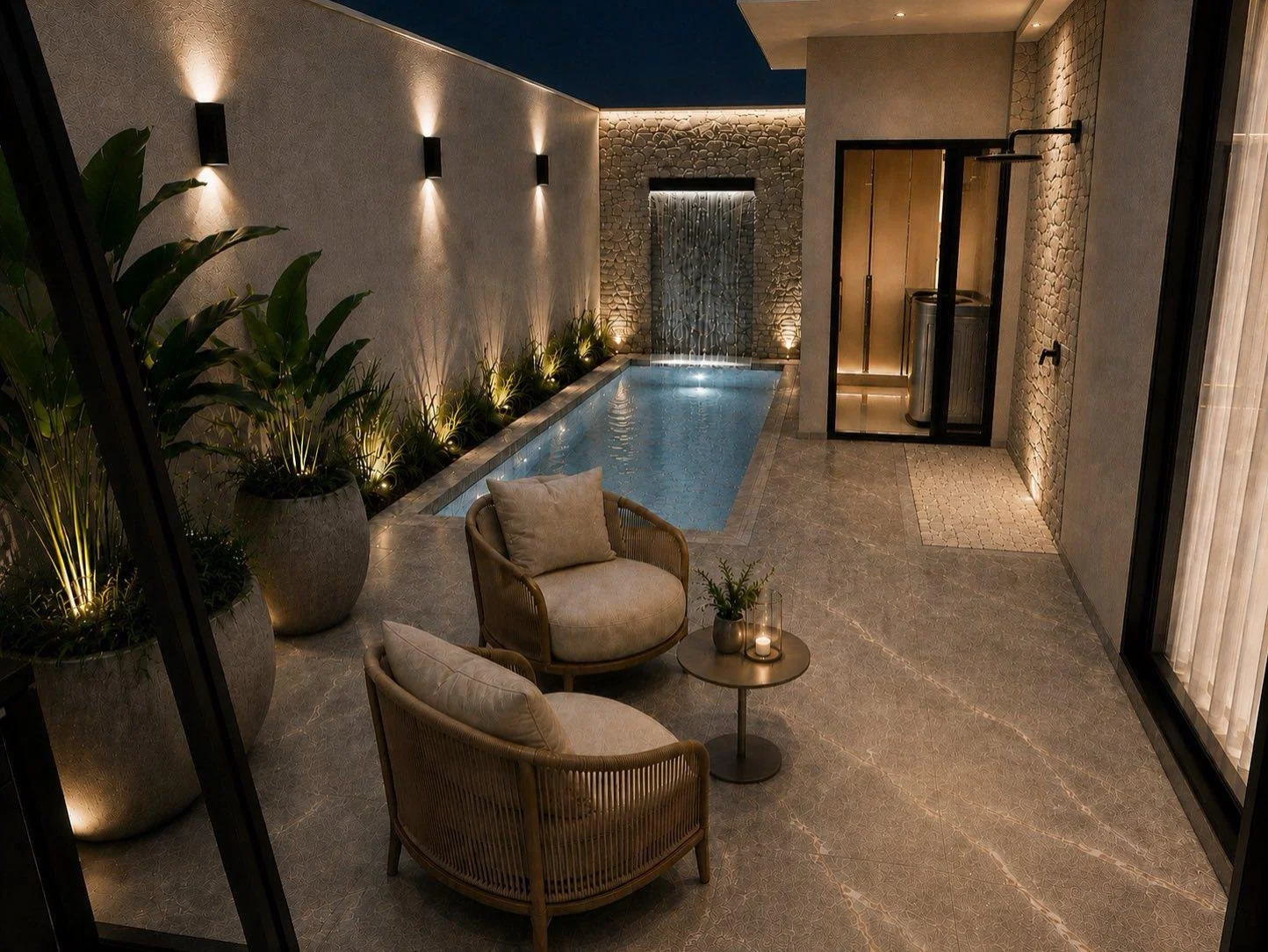La piscina occupa il patio come una lunga lama d’acqua, affiancata dal verde e dalla parete in pietra della cascata.