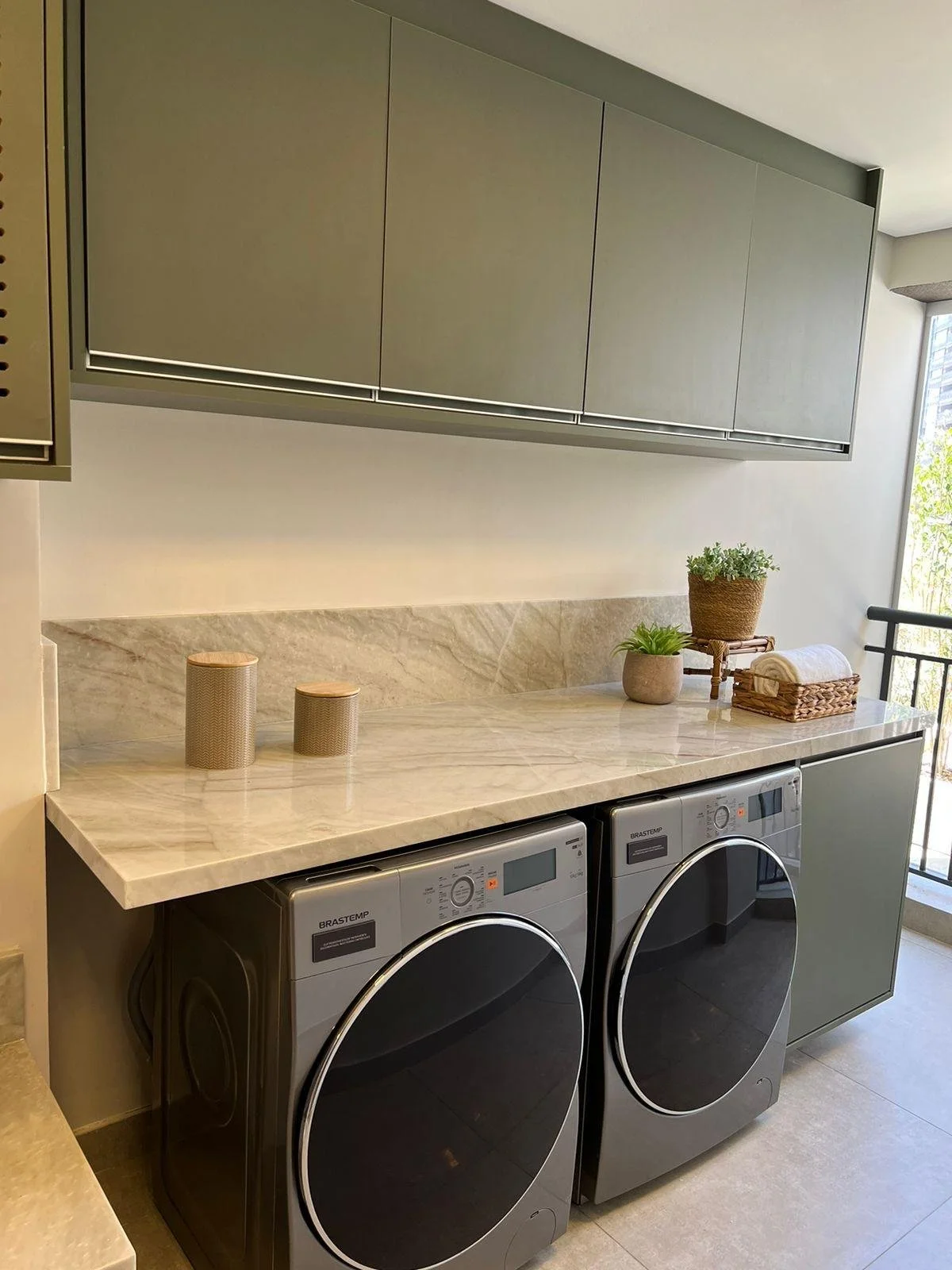 Armadi verdi, piano marmo naturale e apparecchiature moderne. L'ambiente luminoso e ordinato facilita l'organizzazione e l'uso quotidiano.