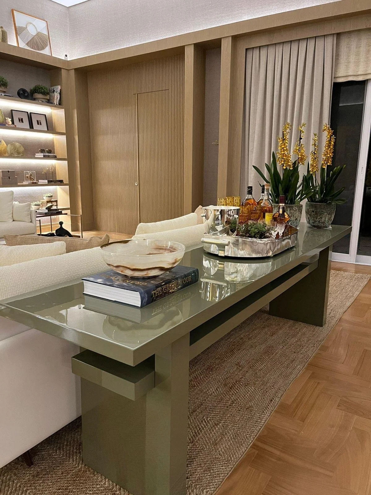 Bar elegante con bottiglie di vino, bicchieri decorativi e piante verdi, perfetto per uno spazio di intrattenimento moderno. Il design minimalista rende l'ambiente raffinato e pratico.