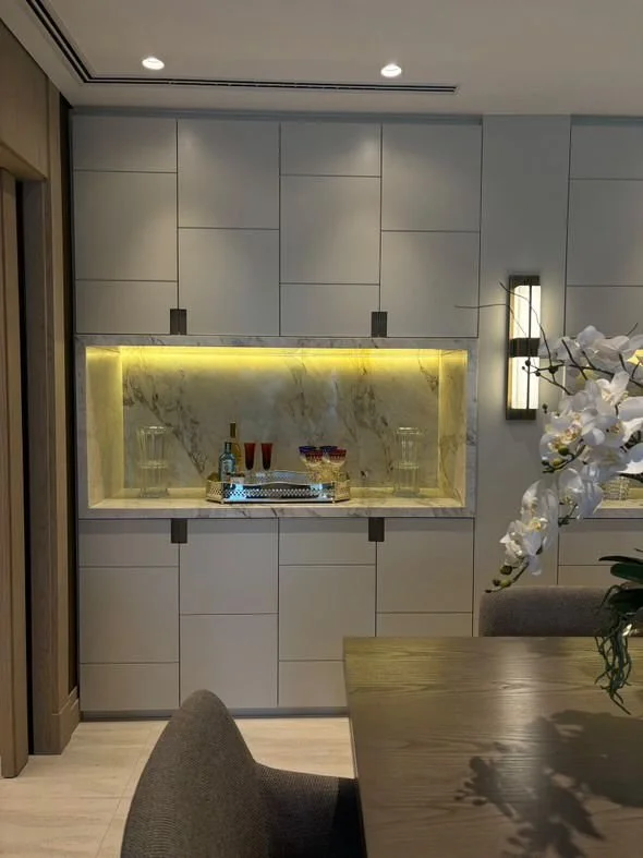 Armadio su misura con nicchia in marmo Calacatta: un punto luce elegante che valorizza l’area pranzo.