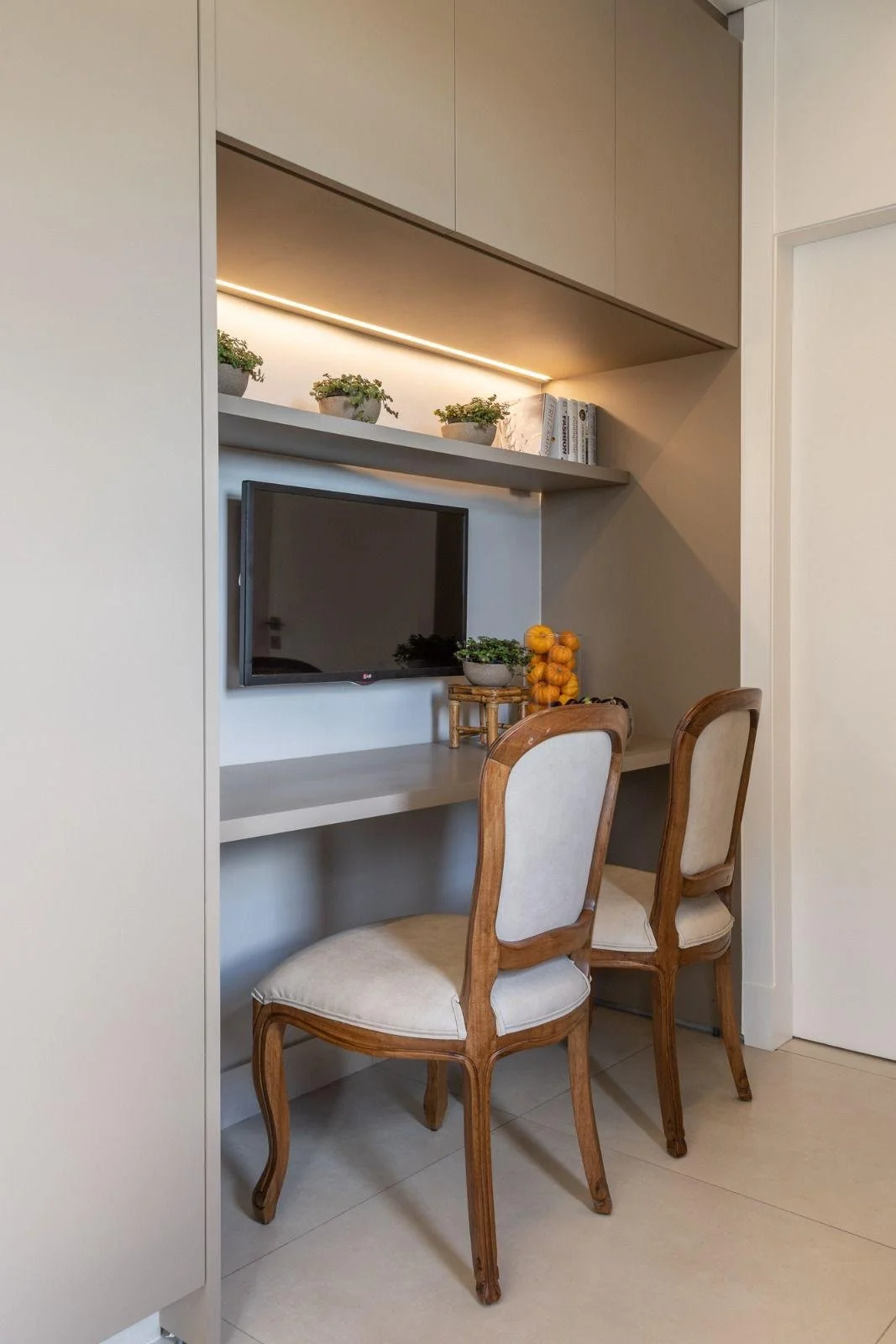 Angolo colazione incassato con mensola luminosa e sedute classiche rivisitate.