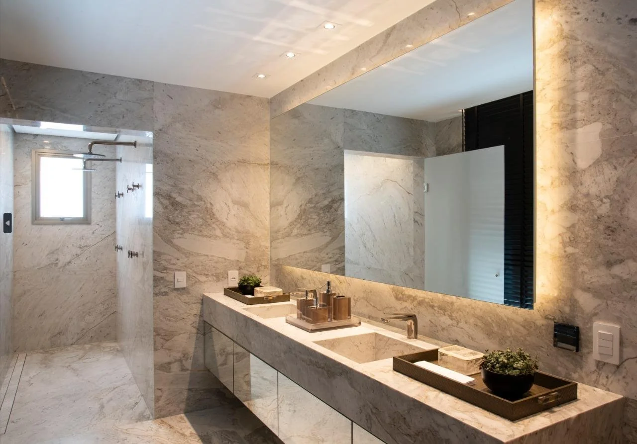 Bagno total marble con maxi specchio e mobile sospeso: luce calda e linee essenziali per un effetto spa.