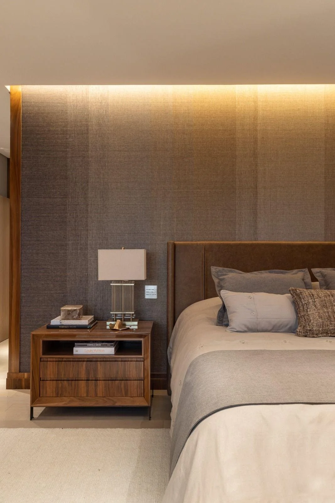 Suite padronale con luci verticali e palette calda: atmosfera hotel-like.