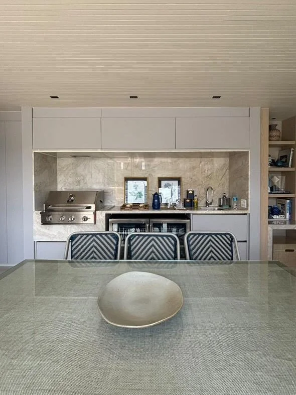 Area cucina/gourmet con barbecue, lavello e cantinetta sotto-top, pensata per momenti conviviali in stile moderno.