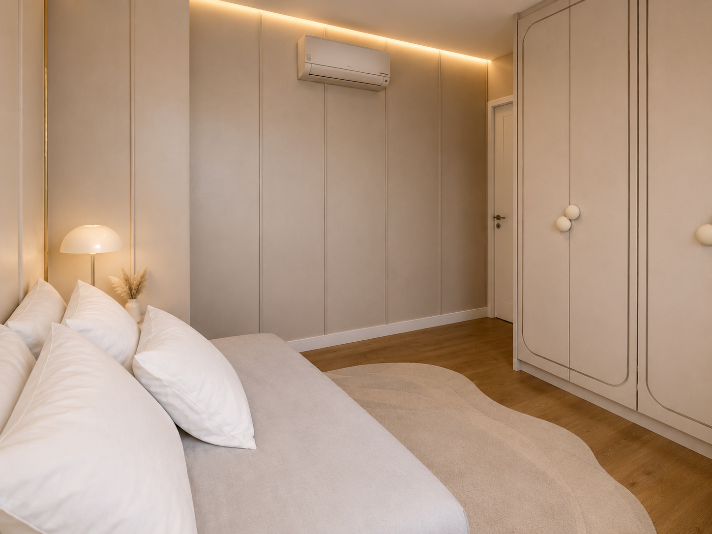 Una vista che evidenzia la continuità progettuale tra letto, pareti e armadiatura. L’illuminazione indiretta a soffitto valorizza le superfici neutre e accompagna le geometrie dell’ambiente, contribuendo a una sensazione di comfort e armonia.