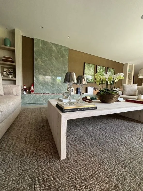 Travertino al centro e pannello TV in marmo verde sullo sfondo: abbinamento elegante e armonioso.