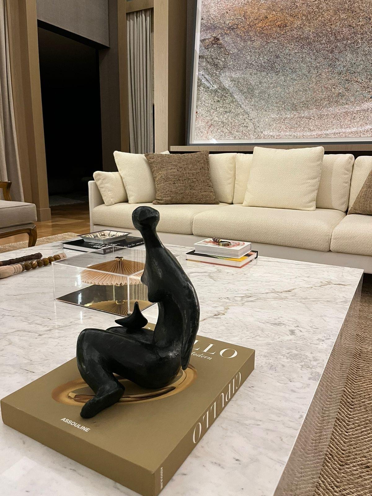 Tavolino in marmo con libri d'arte e accessori eleganti.