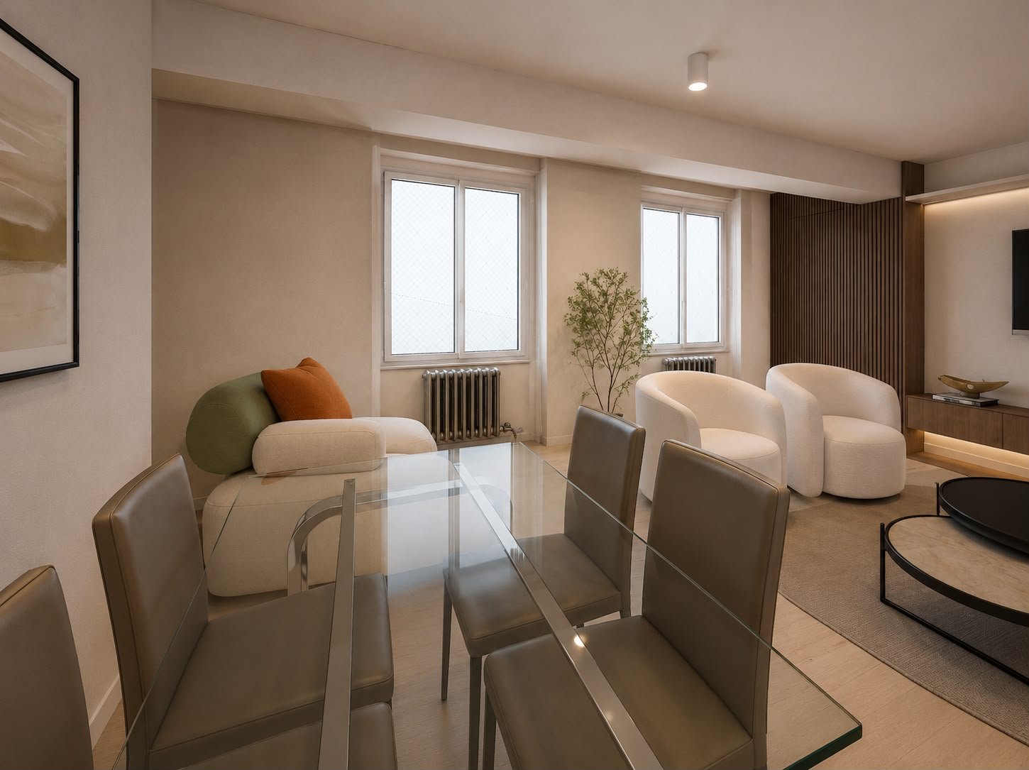Una vista d’insieme racconta la relazione tra sala da pranzo e living. Il tavolo in vetro alleggerisce la composizione, mentre sedute dalle forme avvolgenti, tonalità neutre e accenti di colore creano un’atmosfera elegante e accogliente.