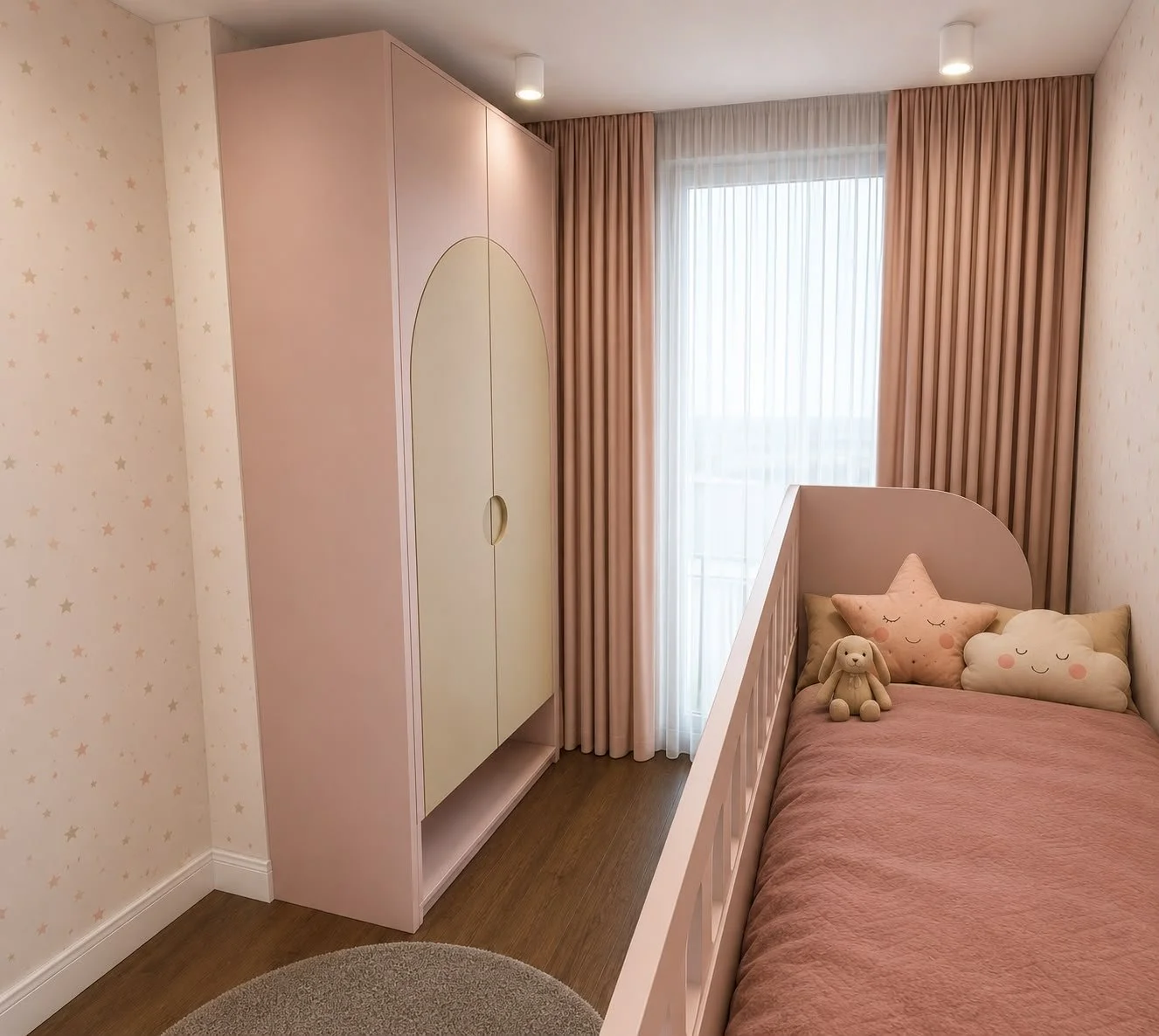 La camera utilizza una palette delicata di rosa cipria, crema e legno. L’armadio presenta un originale inserto ad arco sulle ante, mentre il letto è completato da cuscini decorativi e tessuti coordinati.