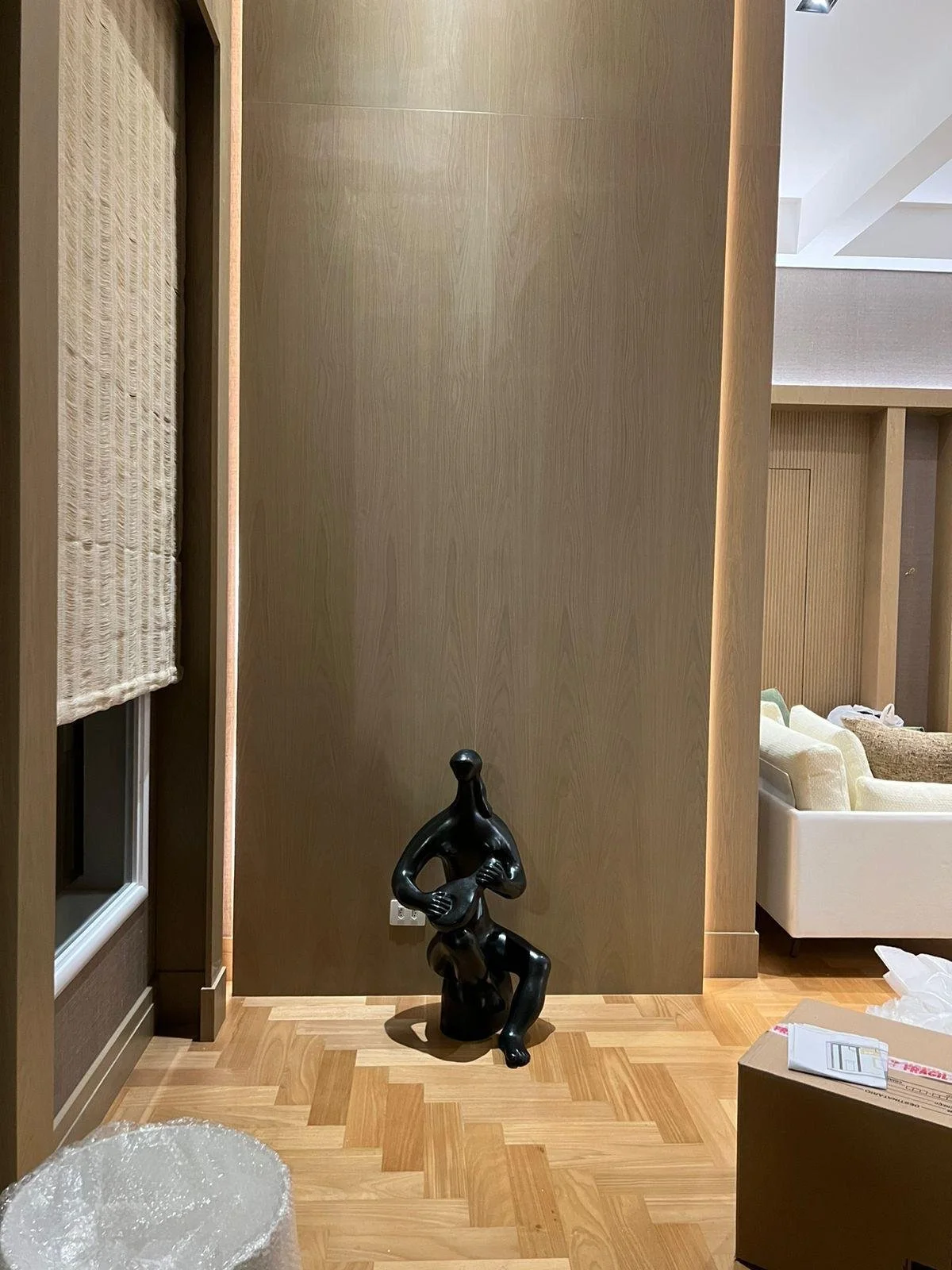 Scultura moderna in un ambiente minimalista, ideale per arredare spazi contemporanei. La combinazione di pareti in tonalità neutre e opere d'arte selezionate aggiunge un tocco di classe.