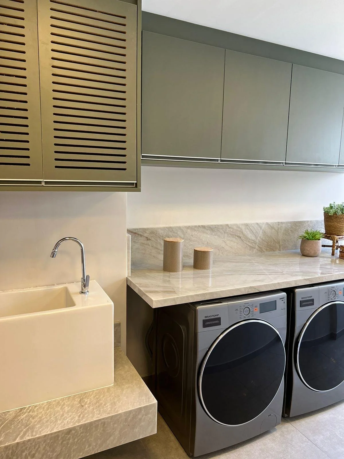 Lavanderia moderna con lavatrice e asciugatrice affiancate.