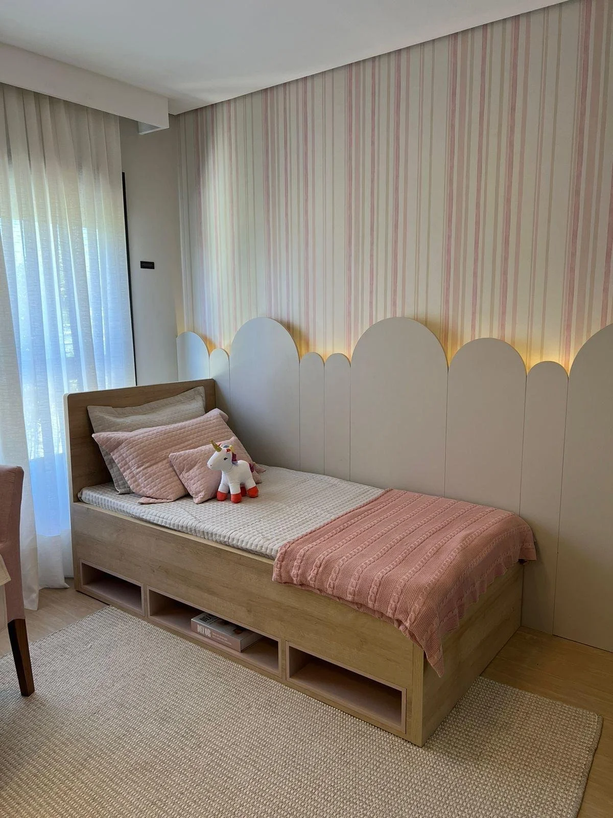 Cameretta da letto 03 in stile minimalista per ragazza. Testiera in falegnameria a righe rosa tema nuvola. Illuminazione soffusa. Letto con contenitore.