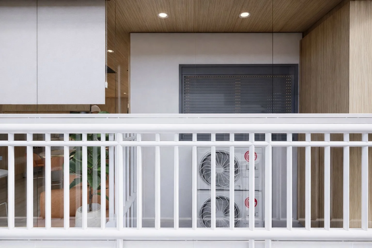 Vista esterna del balcone con parapetto, vetrate e area tecnica dedicata agli impianti di climatizzazione, integrata nel progetto attraverso rivestimenti e arredi su misura.