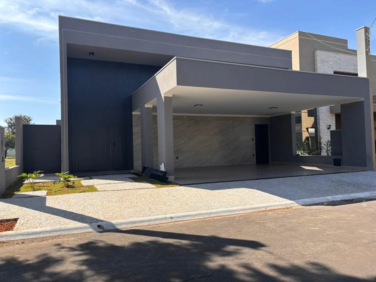 La continuità del piano di calpestio dialoga con le scelte delle superfici ceramiche nel garage insieme alla sobrietà del grigio. 