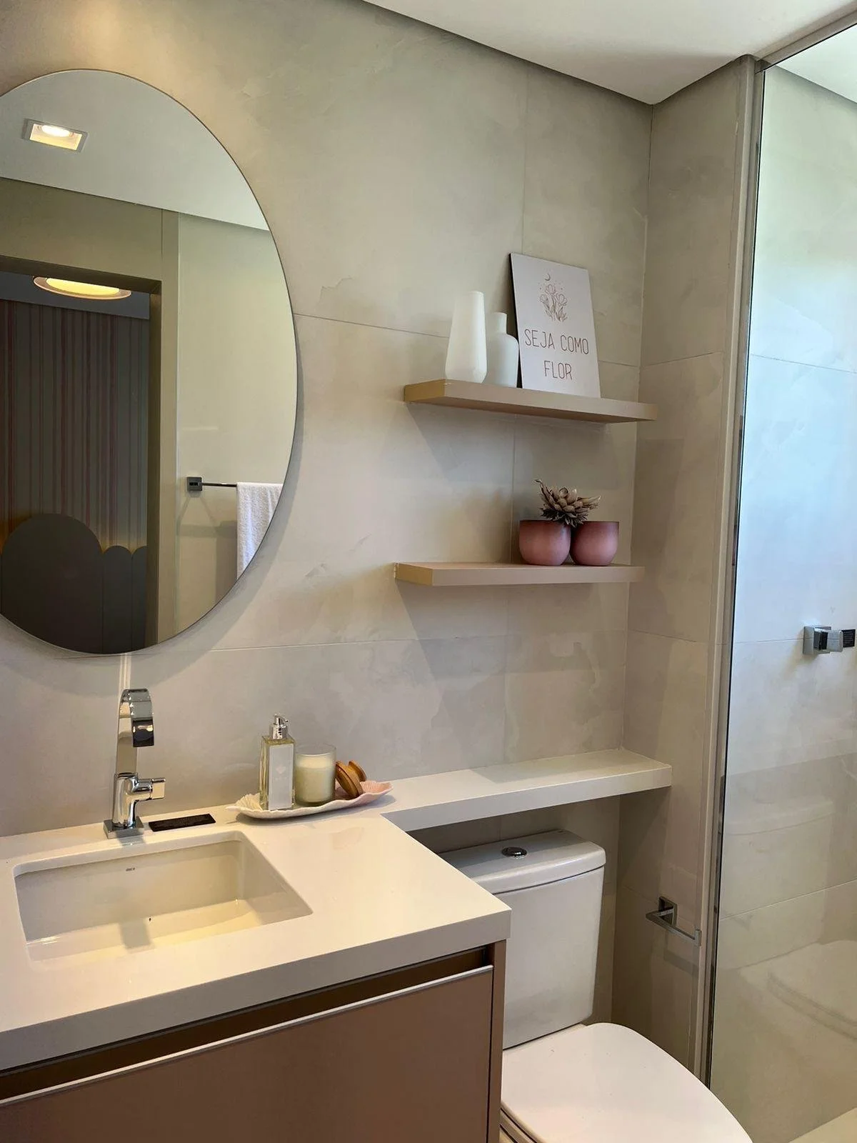 Elegante bagno moderno della stanza 03 con lavabo in marmo bianco e specchio rotondo con illuminazione soffusa.