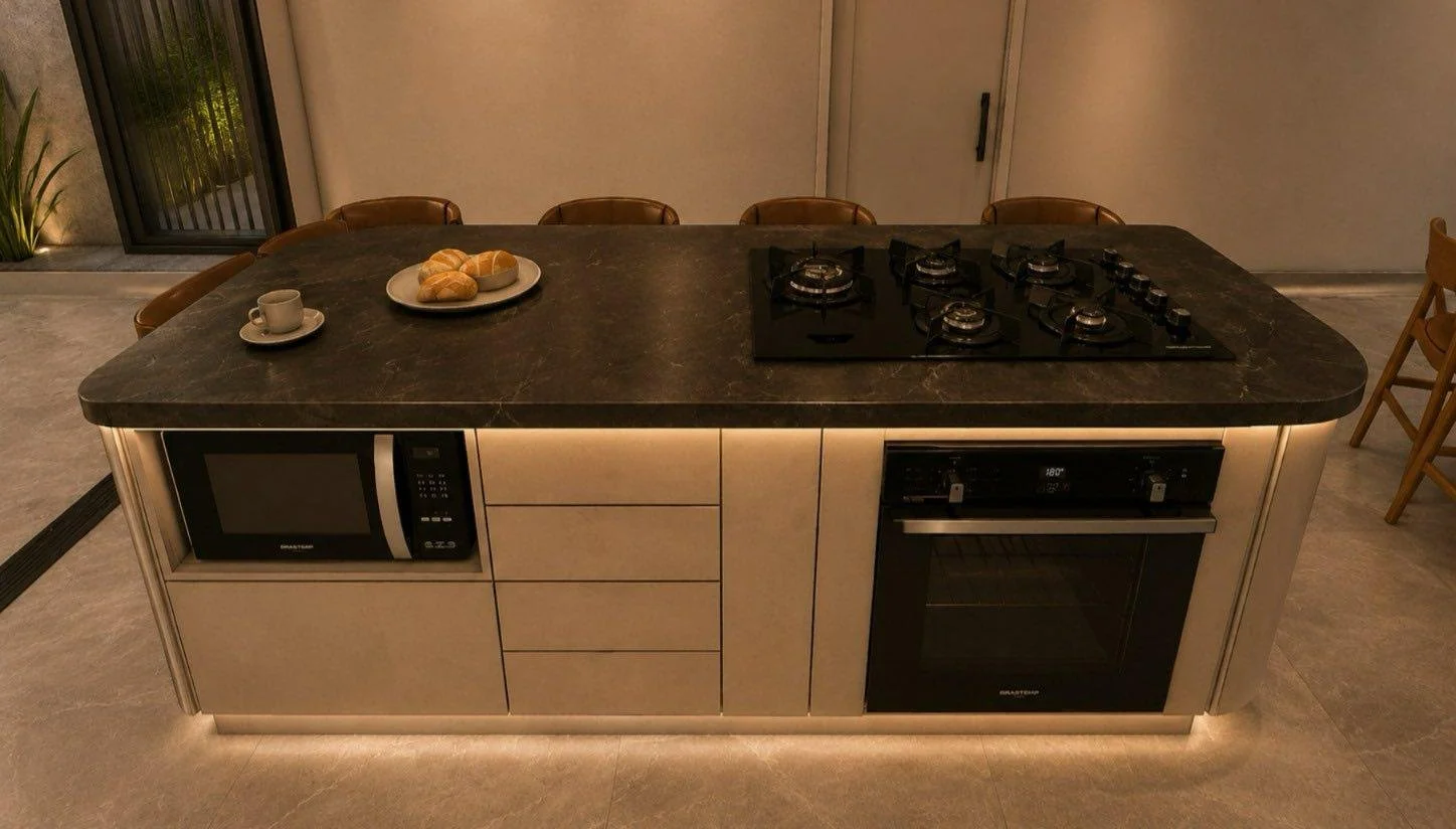 L’isola concentra piano cottura, forno, contenimento e una lunga superficie di appoggio, lasciando libero il resto della cucina.
