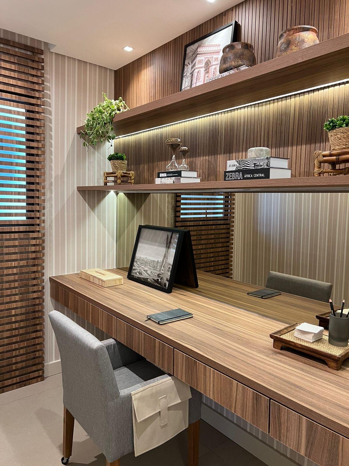 Zona ufficio con scrivania in legno e mensole per libri e decorazioni. 