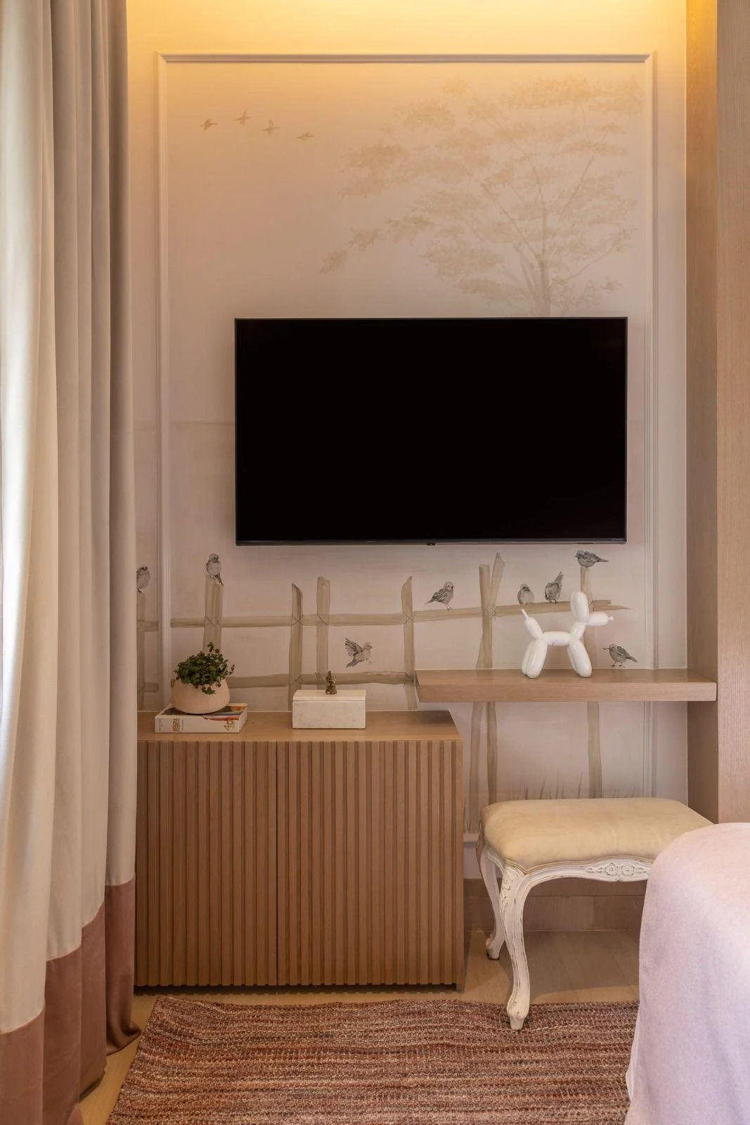 Dettaglio della parete decor con volo di uccellini e mensola minimal sotto la TV.