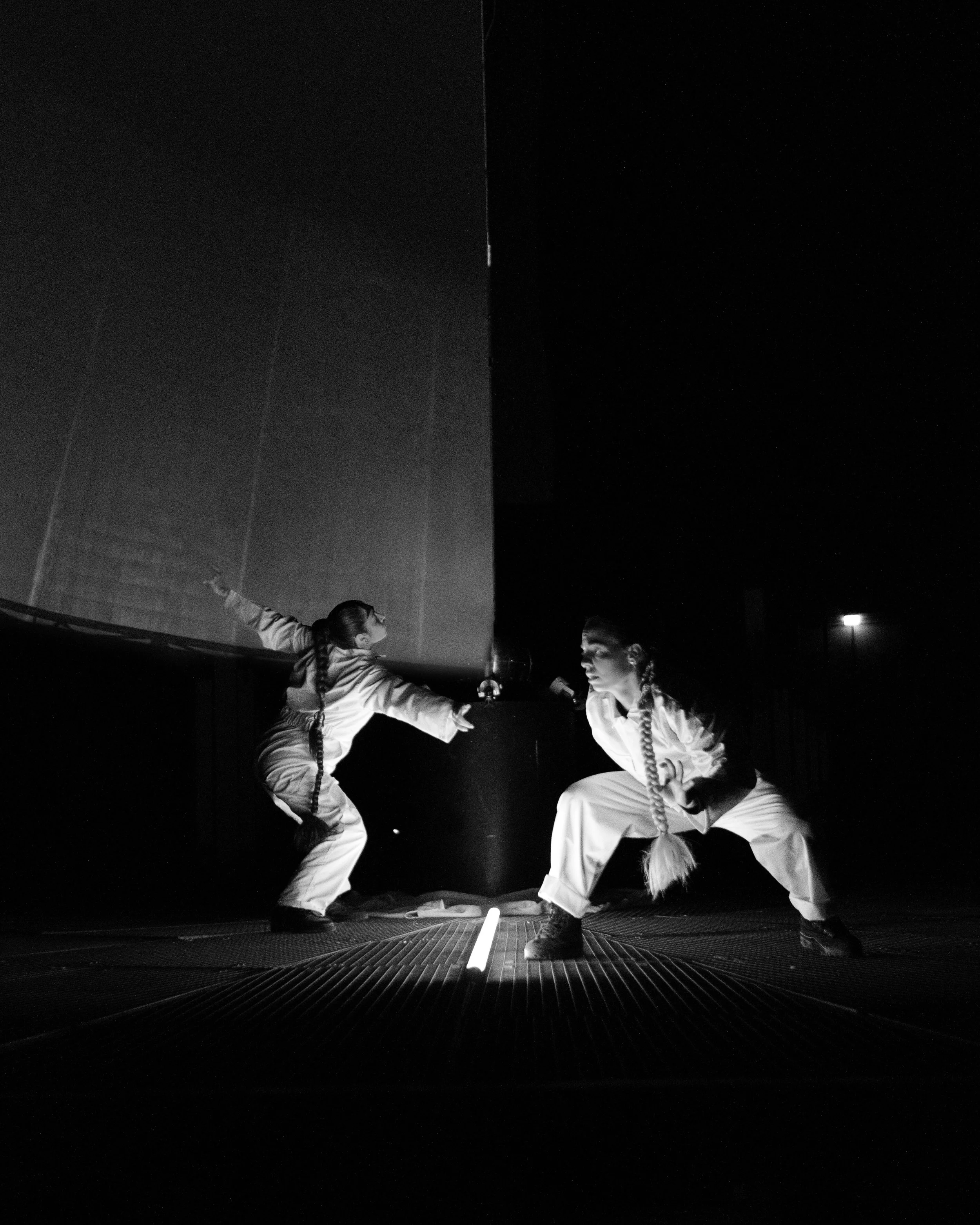 Wide view of performers inside a historic gasometer with large-scale projection mapping across the walls, creating an immersive theatre environment.