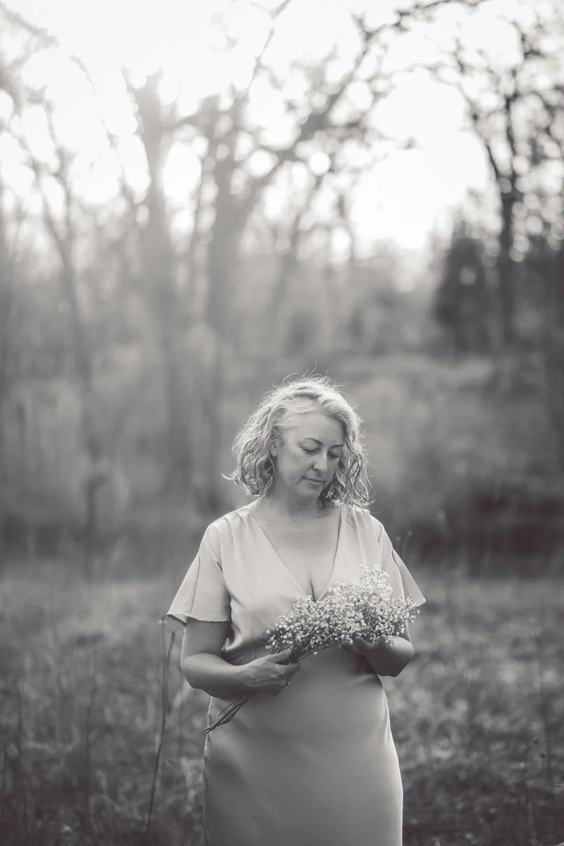 woman photographed in black and white with flowers and silver hair