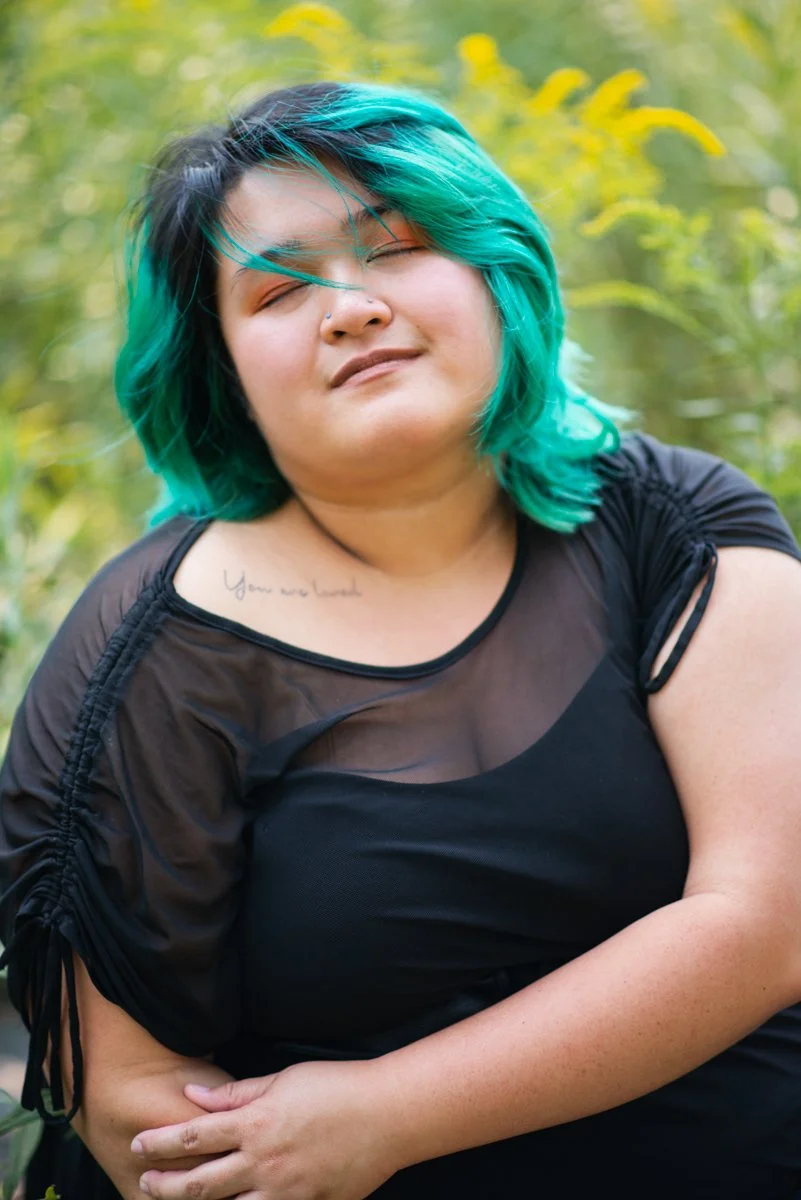 woman with green dyed hair and a tattoo in a portrait