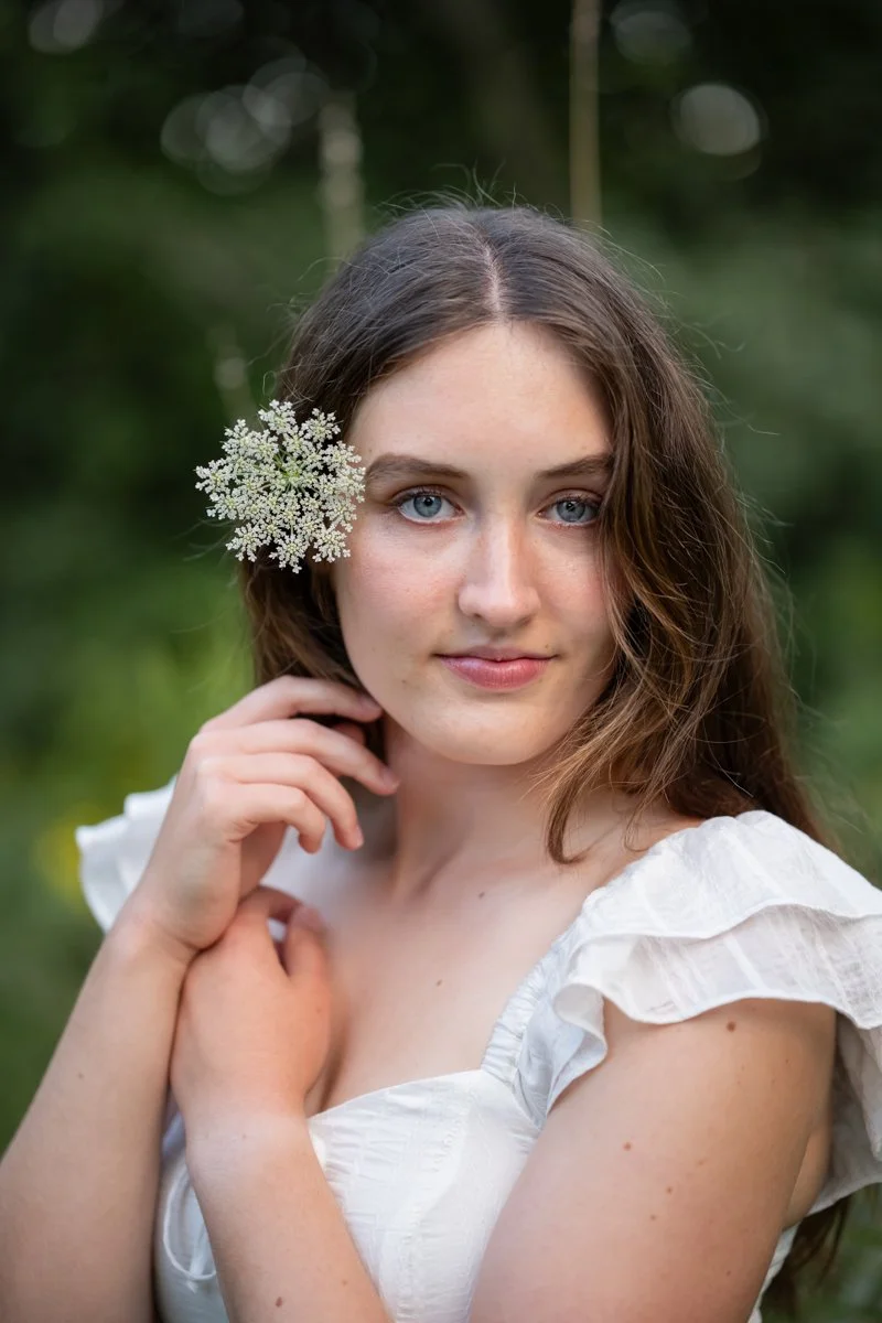 a teen portrait of beauty and nature with a flower in her hair and blue eyes