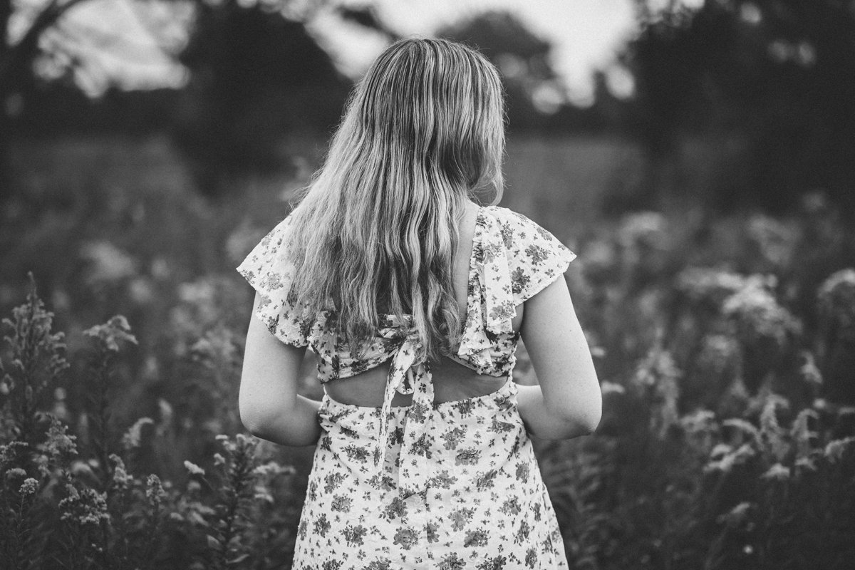 girl in a flowered dress in a field of flowers shot in black and white