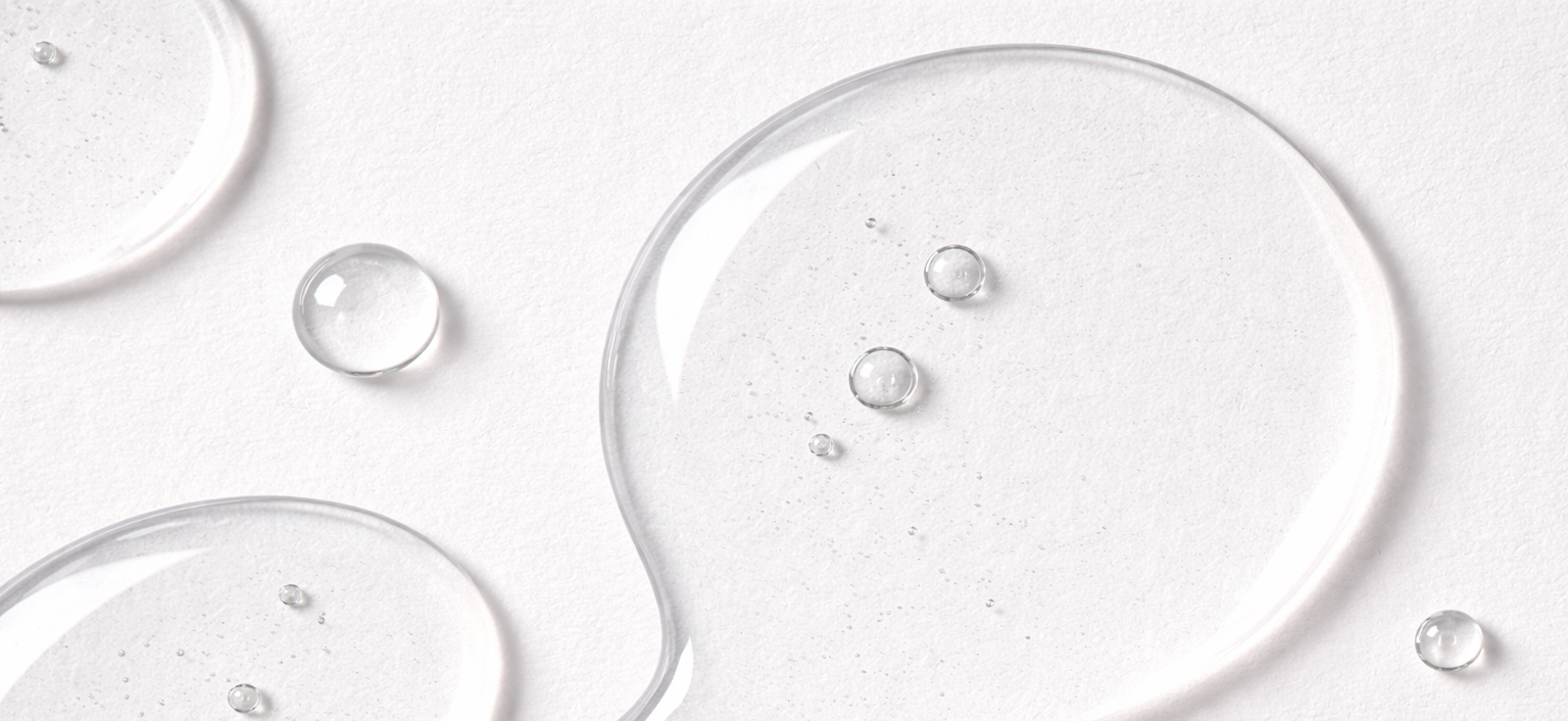 Gennemsigtige dråber og pletter på hvid baggrund.