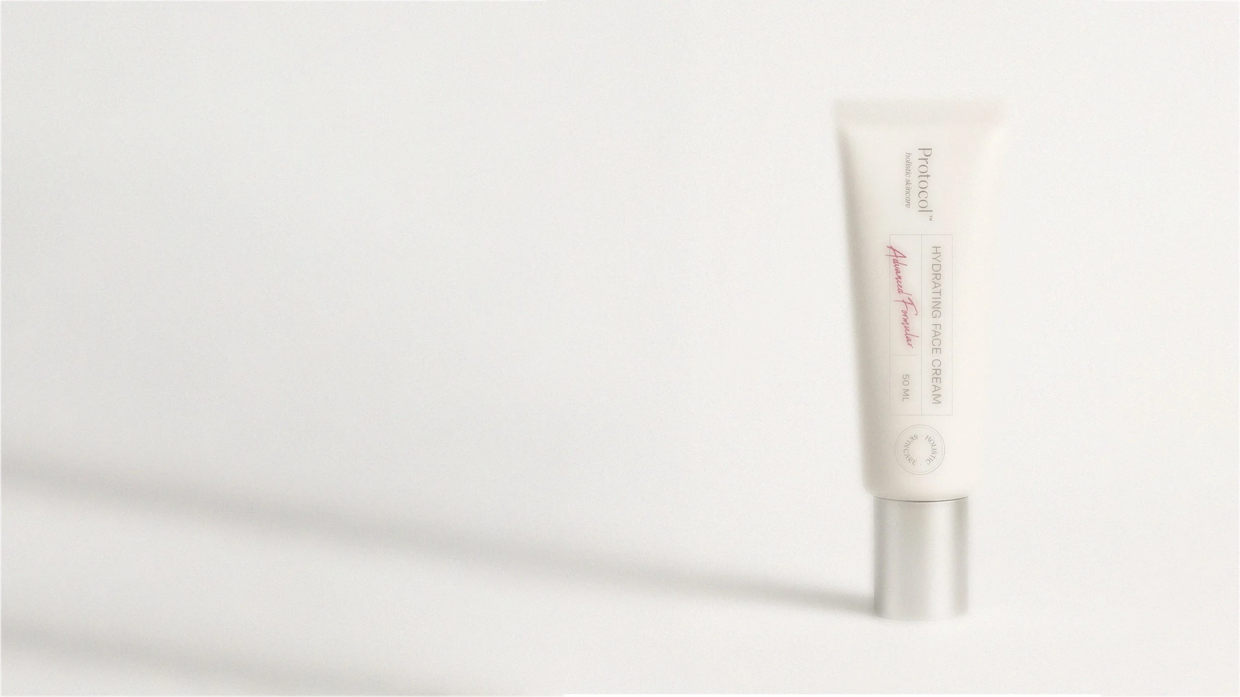 A white tube of hydrating face cream labeled 'Protocil' with pink and black text, lying on a white surface, casting a shadow.