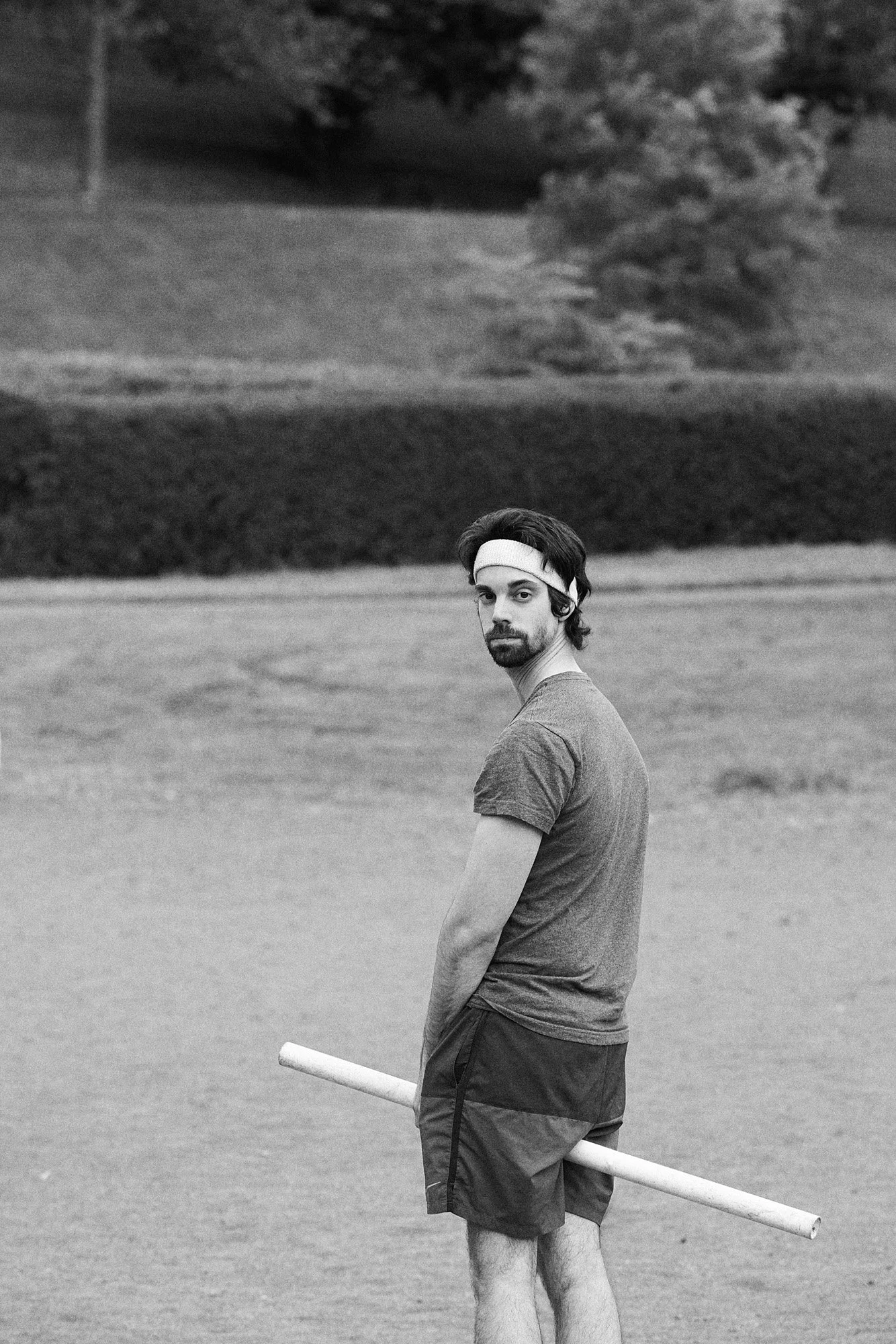 A Quidditch player stands in Glasgow, holding a length of PVC pipe between his legs in place of a broom.
