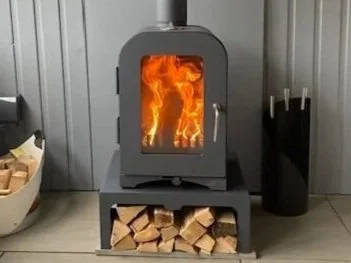 Compact wood-burning stove heating a tiny home, efficient and cosy, ideal for off-grid living or where supply is limited.